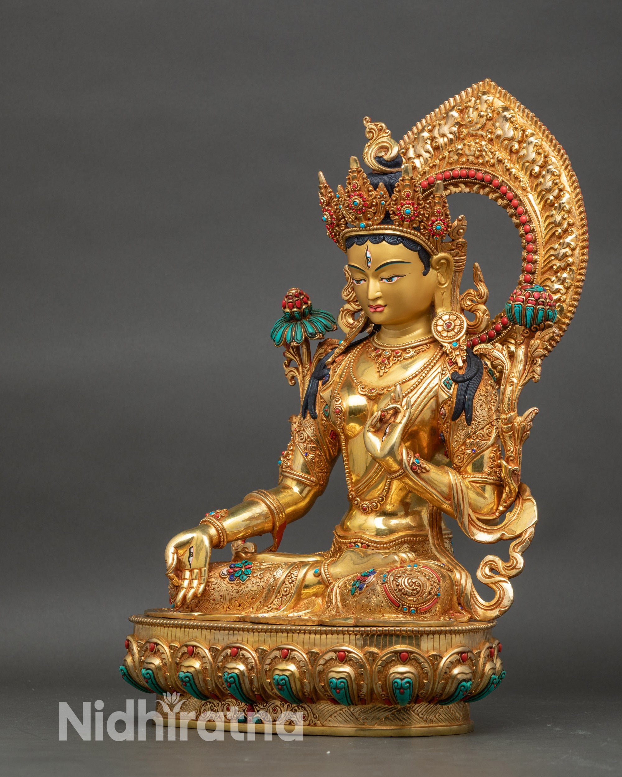 Left view side of White Tara statue showing intricate gold-gilded floral details