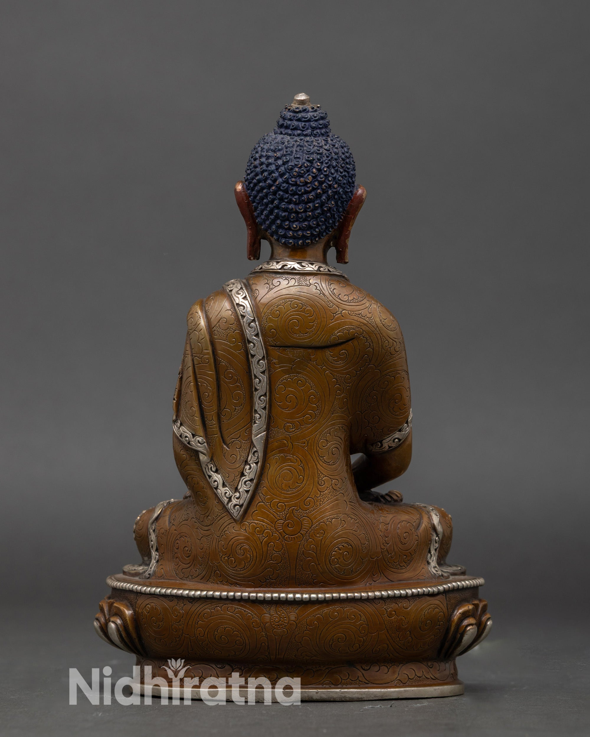 Back view of traditional Amitabha Buddha statue with lotus pedestal and sacred detailing