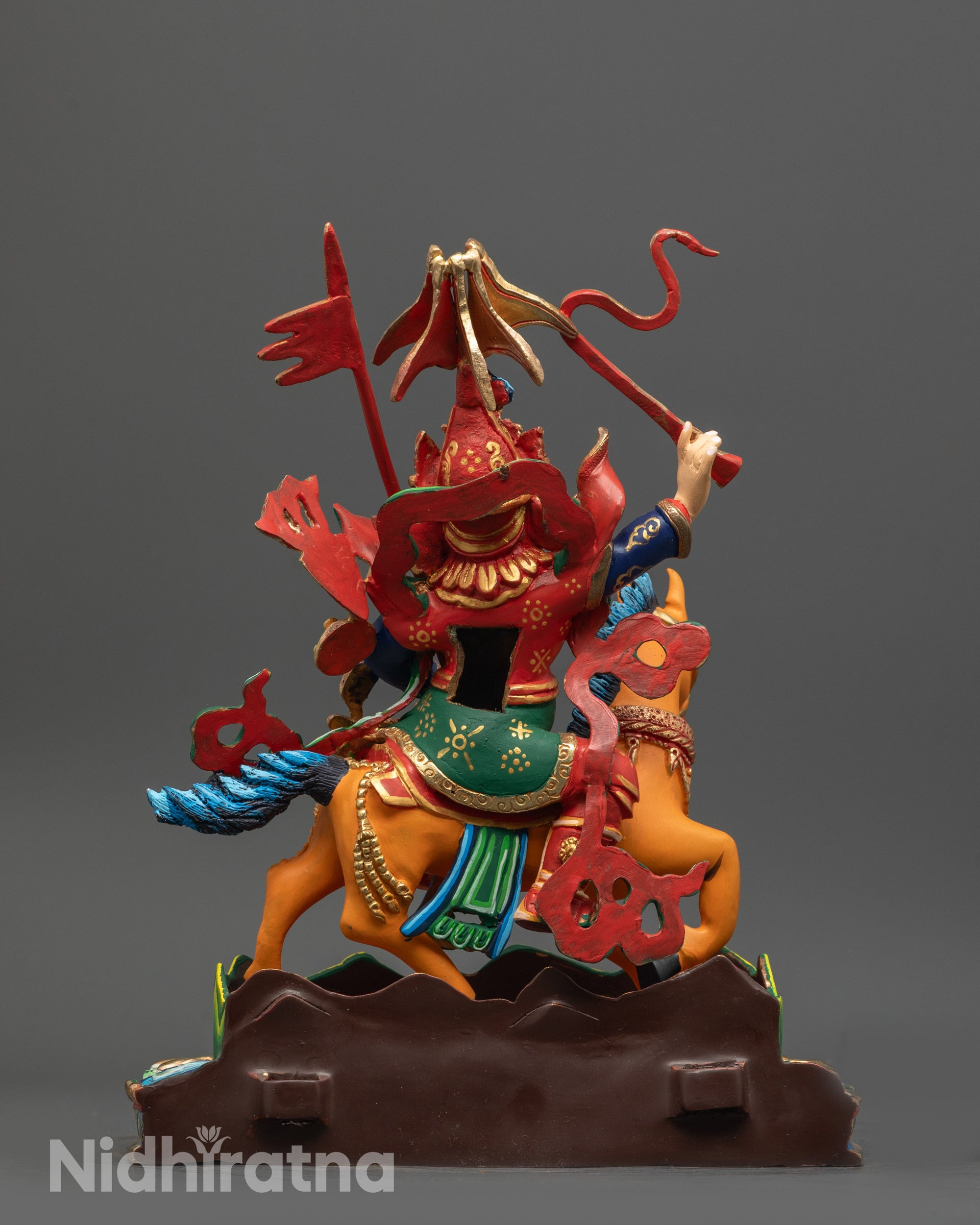 Back view of King Gesar statue showing carved attire and painted details on copper base