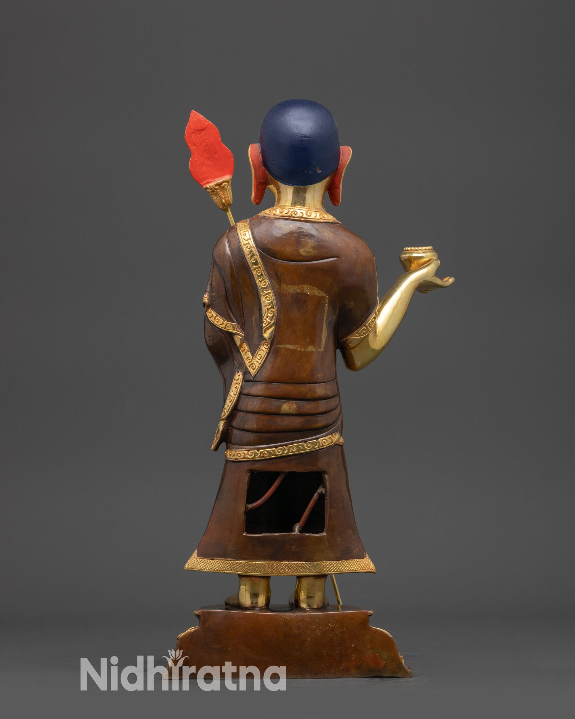 Back view of Shariputra disciple statue showing carved robes and copper alloy finish