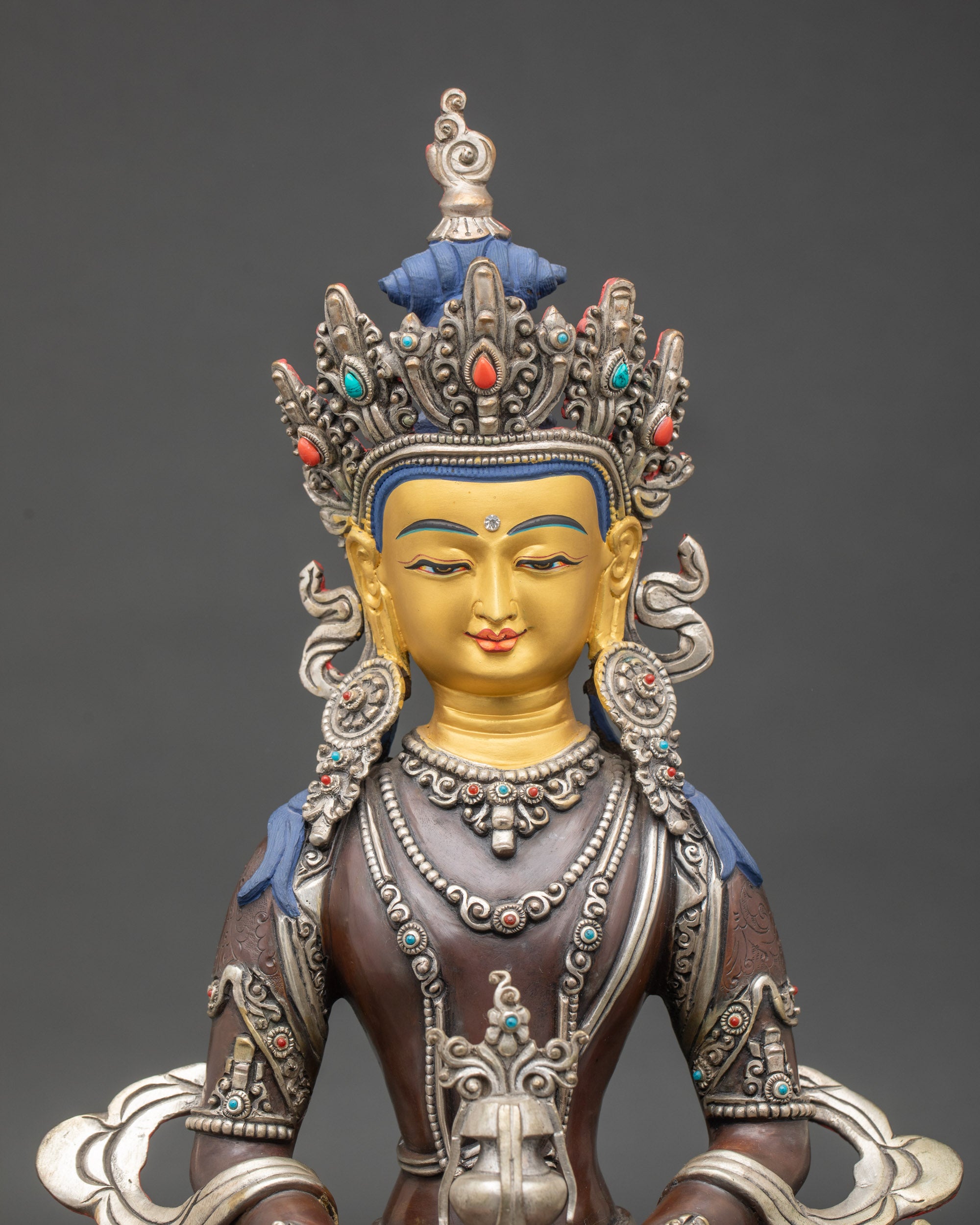 Close-up of Amitayus Buddha statue showing intricate silver oxidation and semi-precious stone detailing