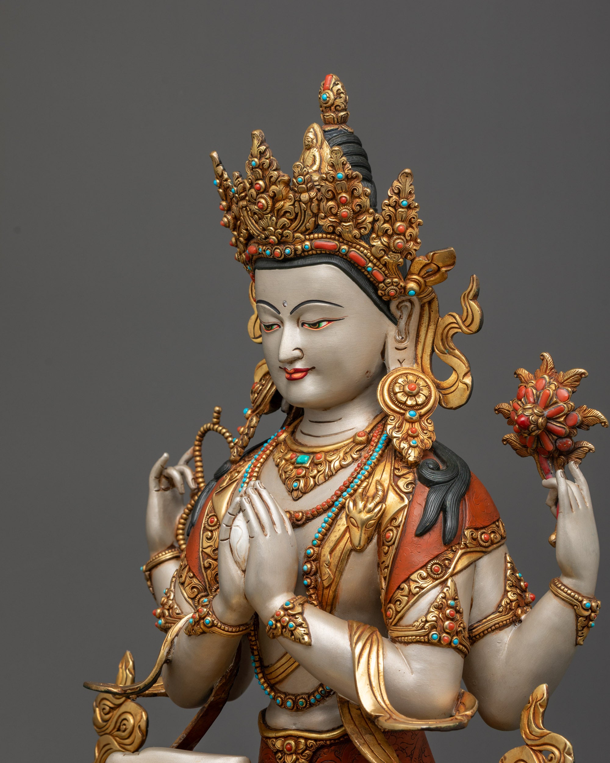 Detailed side view Chenrezig statue highlighting intricate garments and lotus seat