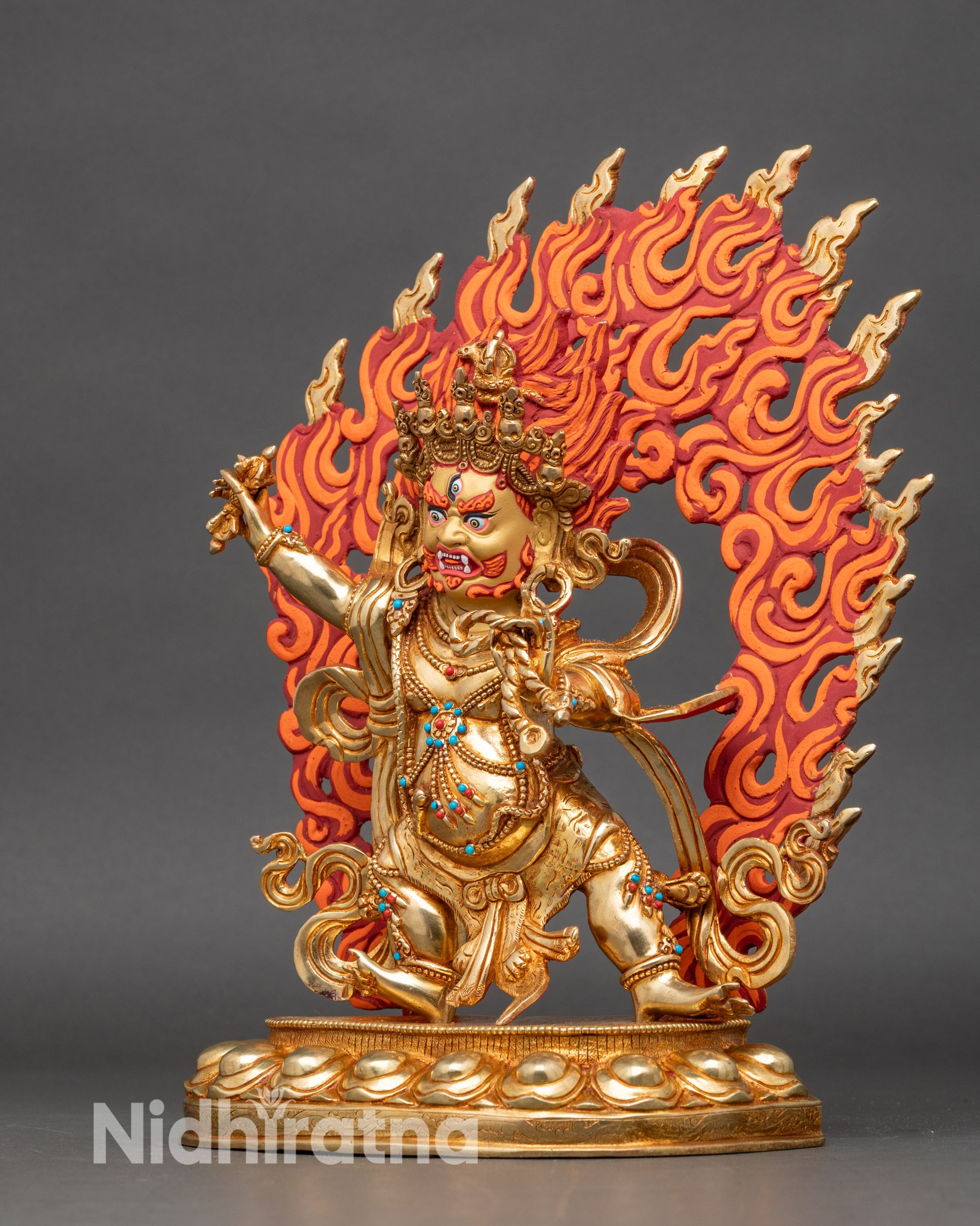 Side view of Vajrapani protector deity statue, holding vajra, wrathful and muscular form