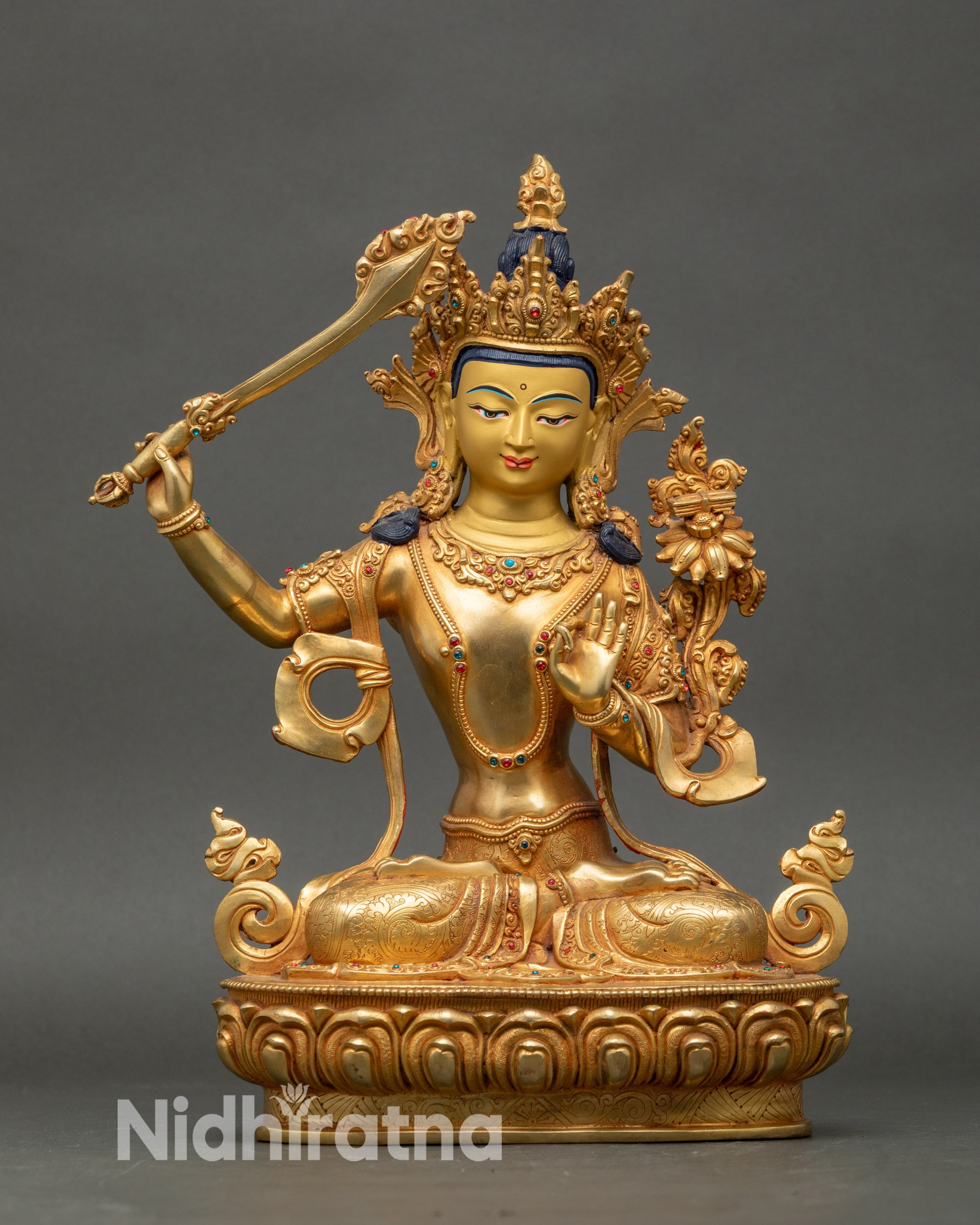 Front view Manjushri statue with utpala flower, double-edged sword, lotus throne