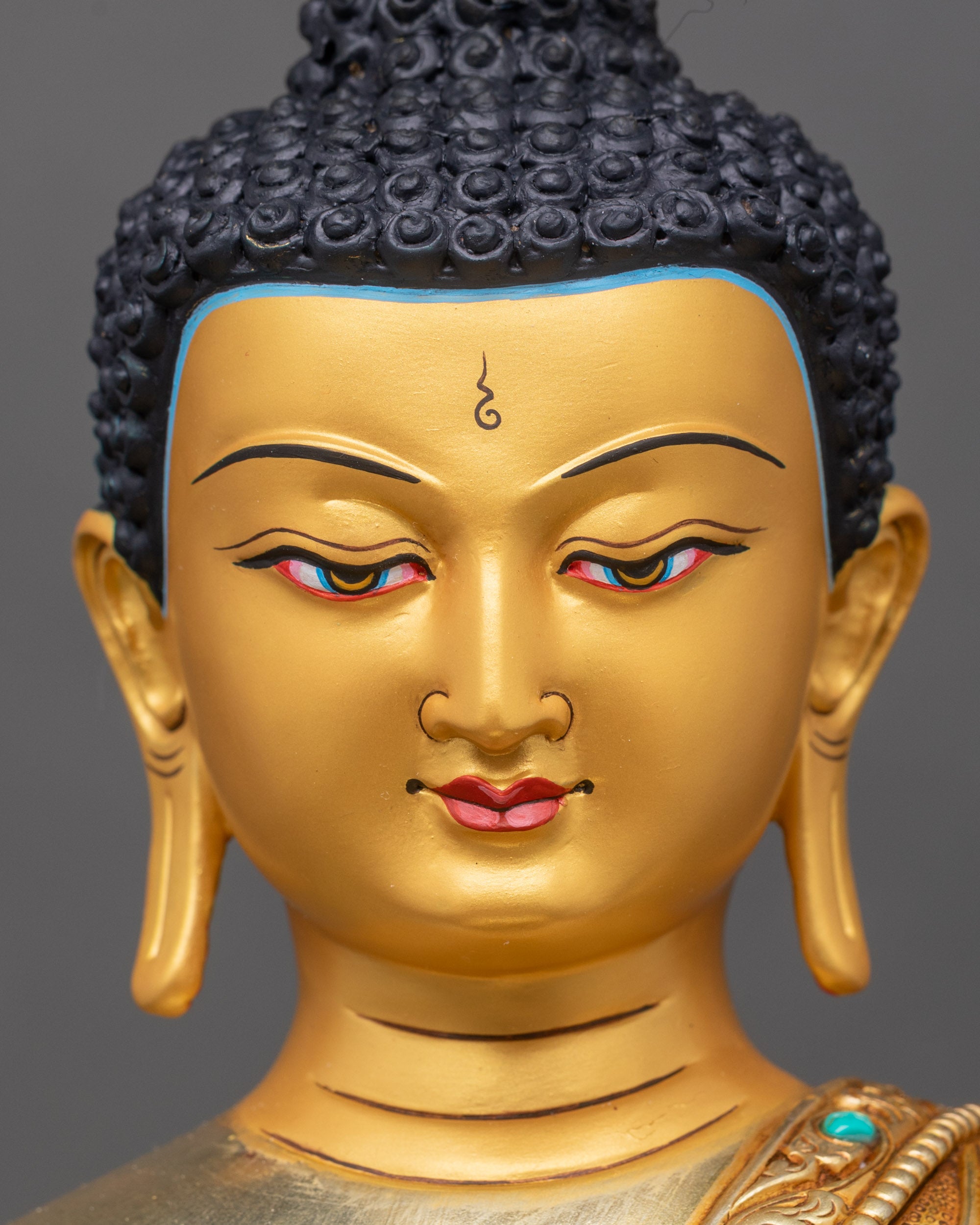 Face close-up of Shakyamuni Buddha with serene expression and gold-painted finish