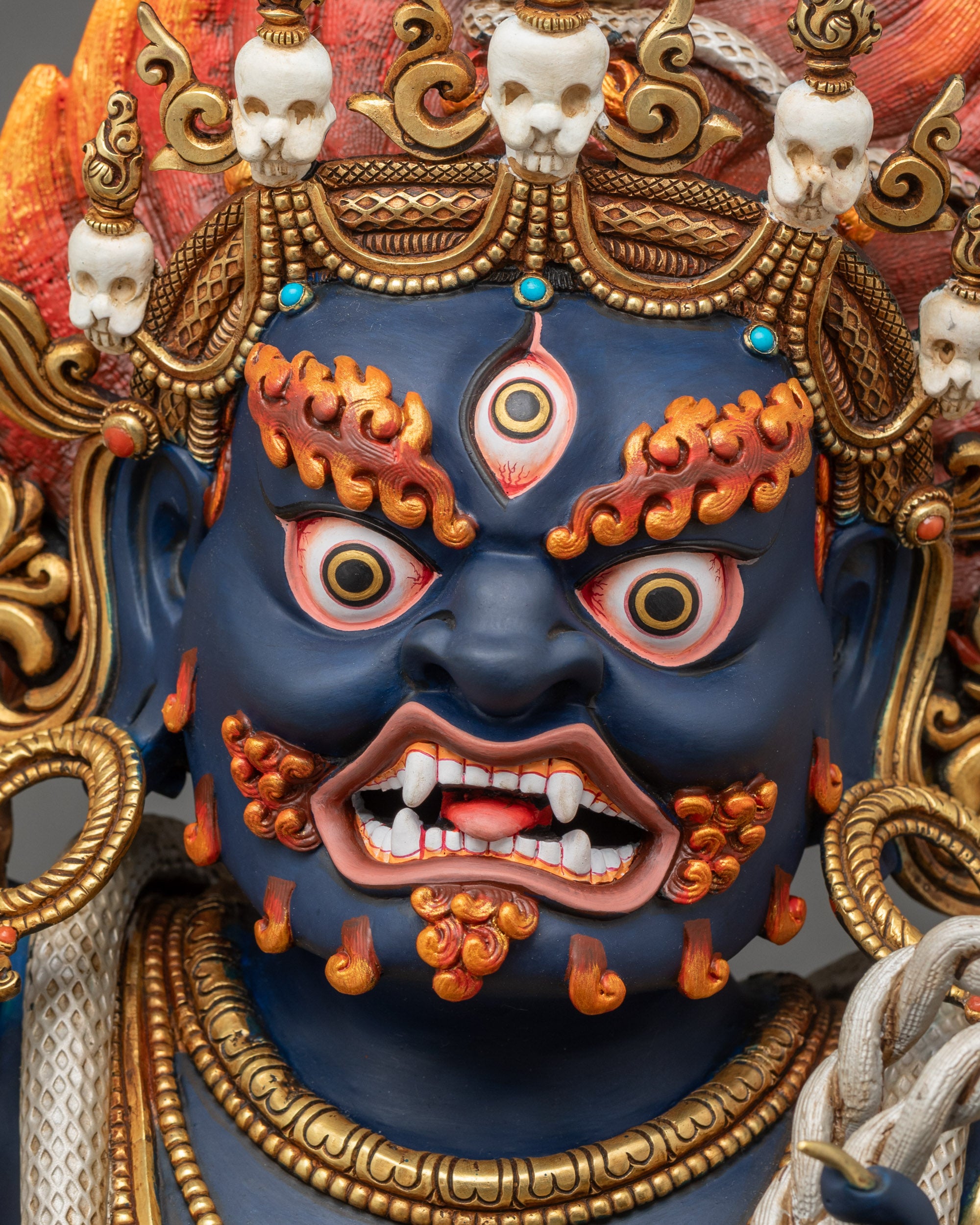 Face close-up of Vajrapani with third eye, five-skull crown, and wrathful expression
