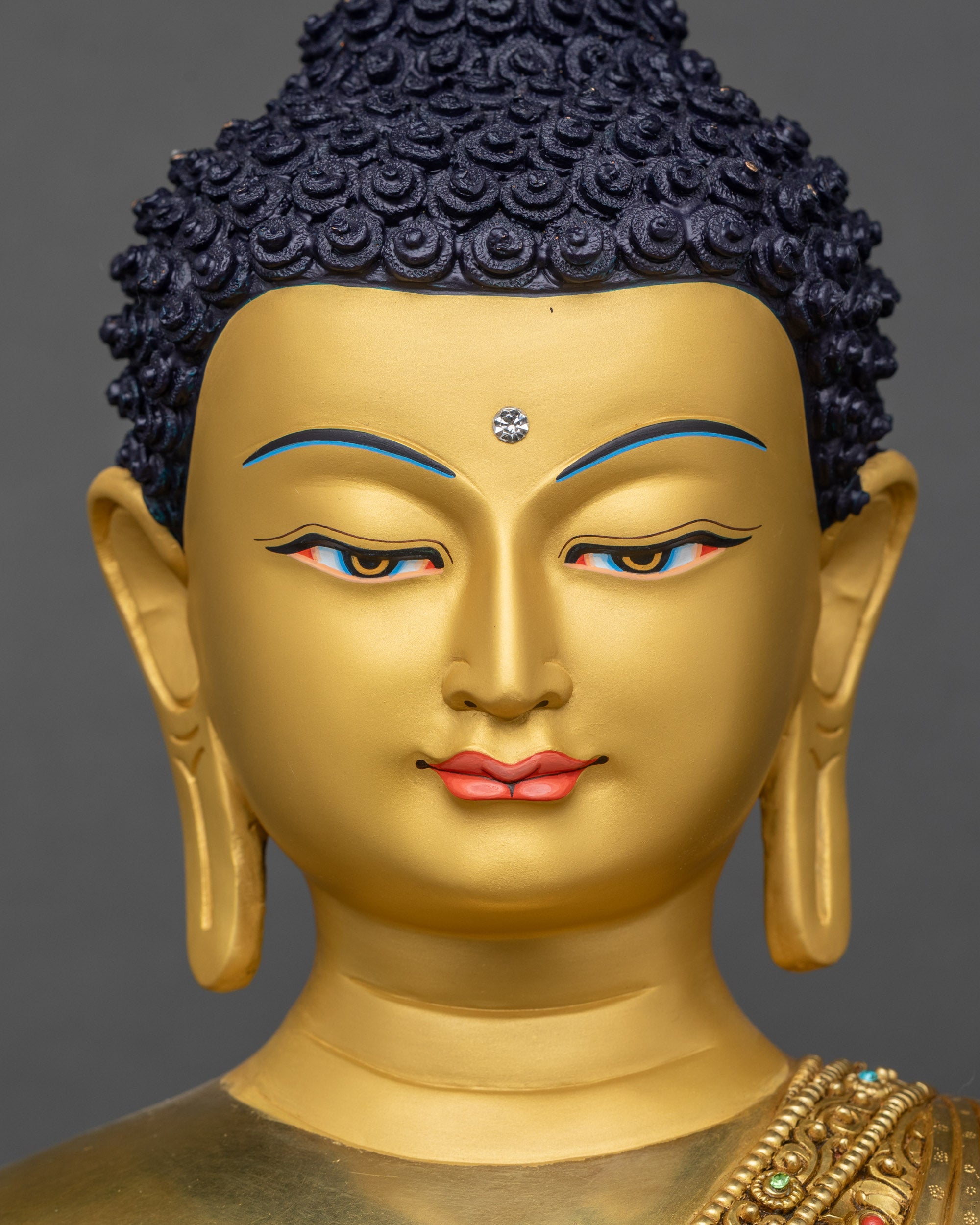 Face close up of Amitabha Buddha with serene gold-painted expression and halo