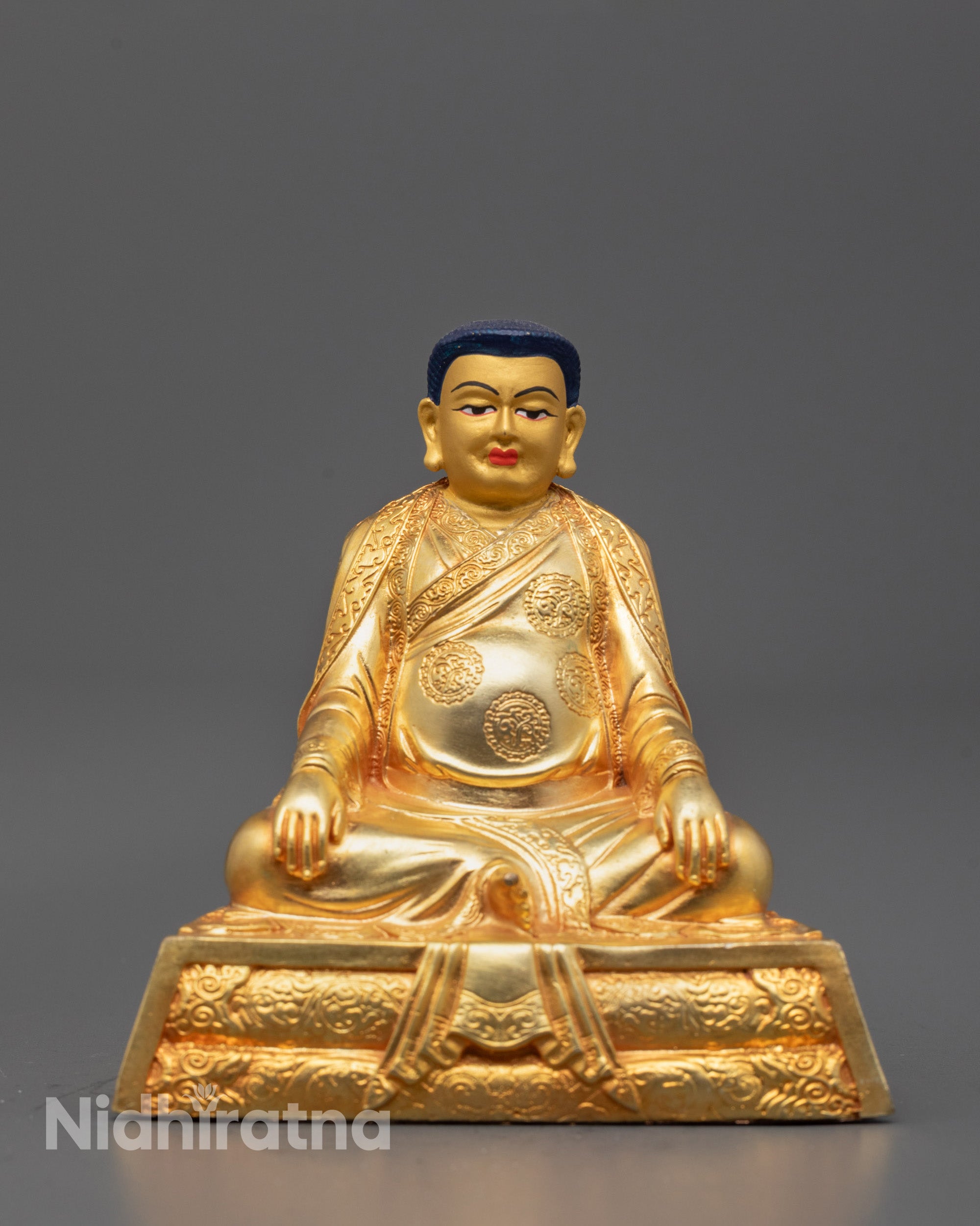 Front-view of Copper Marpha statue seated in meditation posture with serene facial expression
