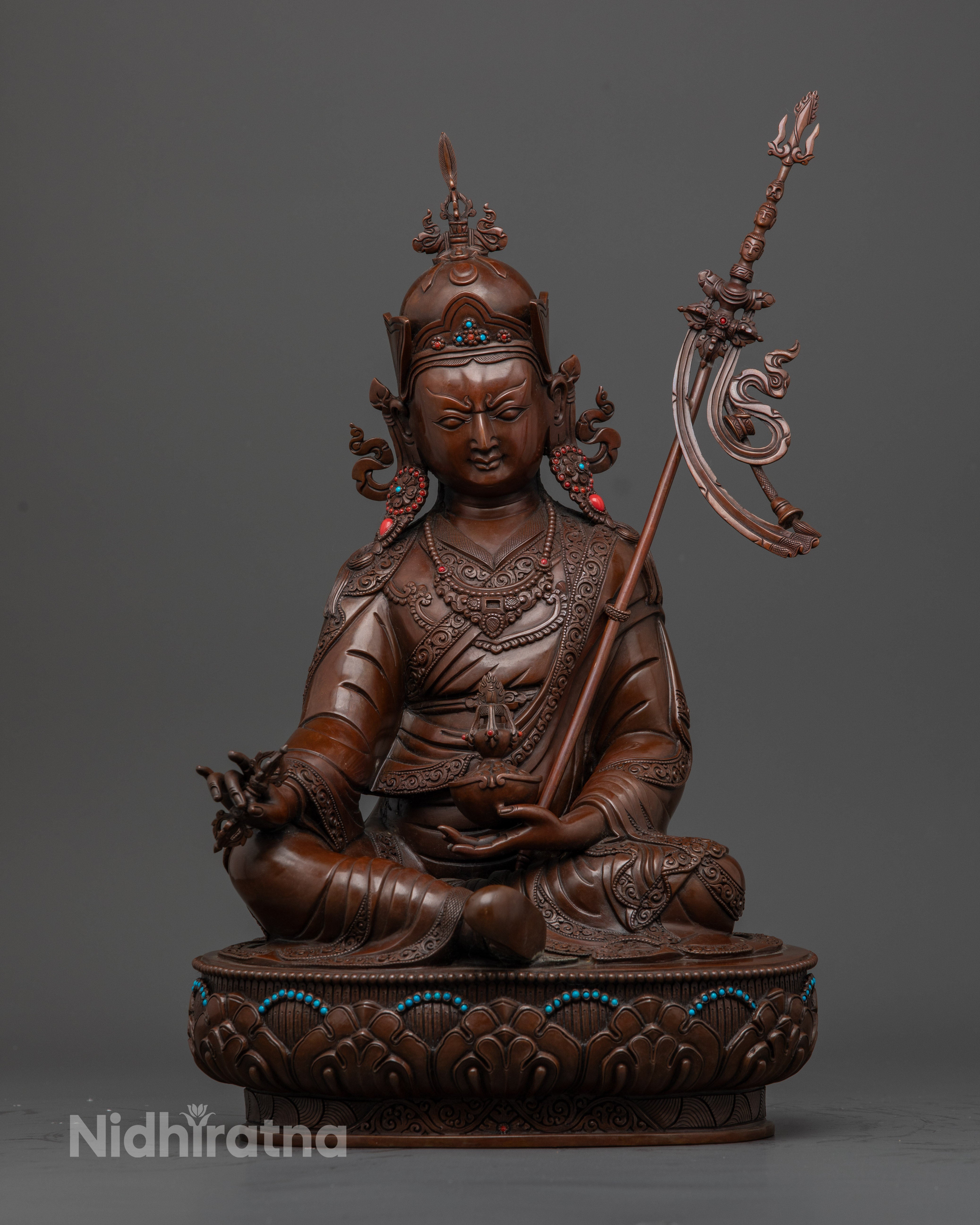 Front-view of Handcrafted oxidized copper Guru Rinpoche statue seated on a lotus base with skull cup