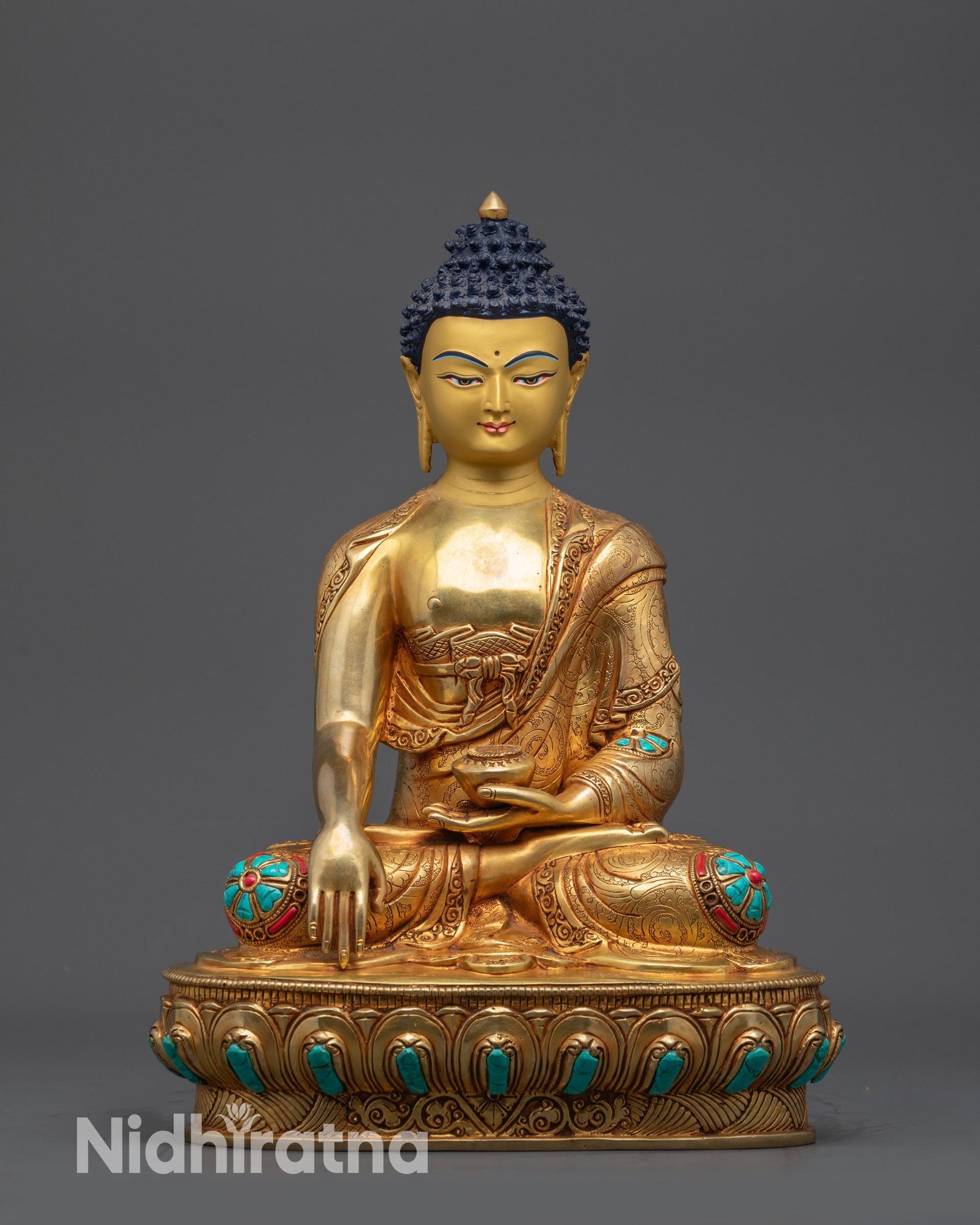 Front view Buddha Shakyamuni statue on lotus seat with gold-gilded face and robes