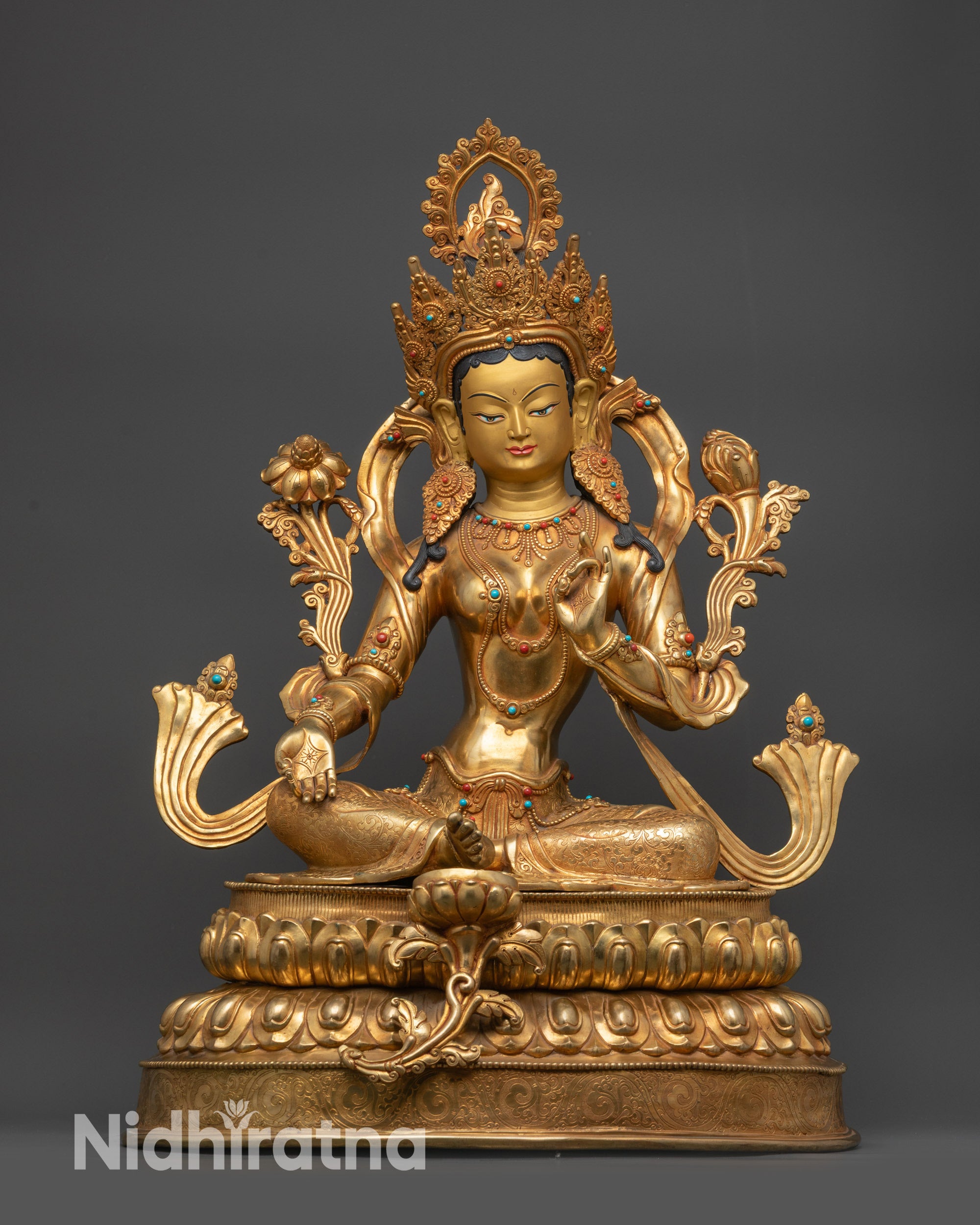 Front view Green Tara statue seated on double-layered lotus pedestal with floral carvings