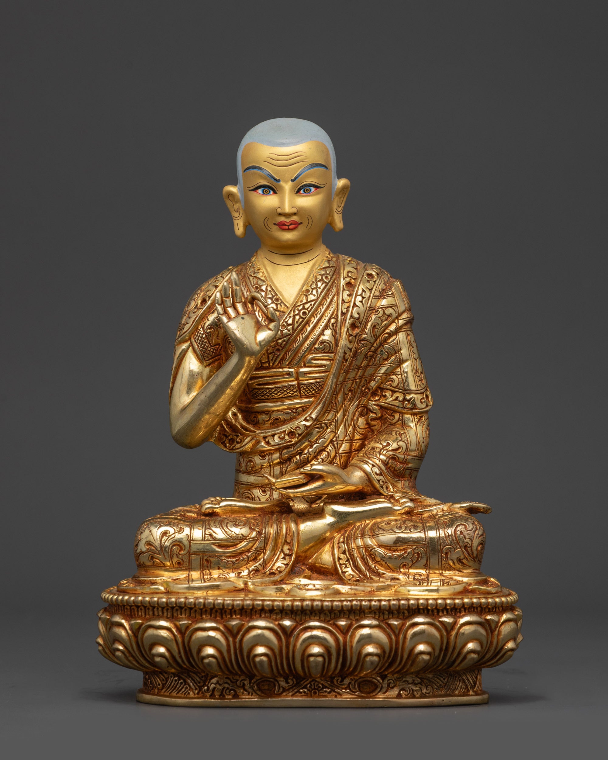 Front view Gyaltsab Je disciple statue holding scriptures with contemplative pose
