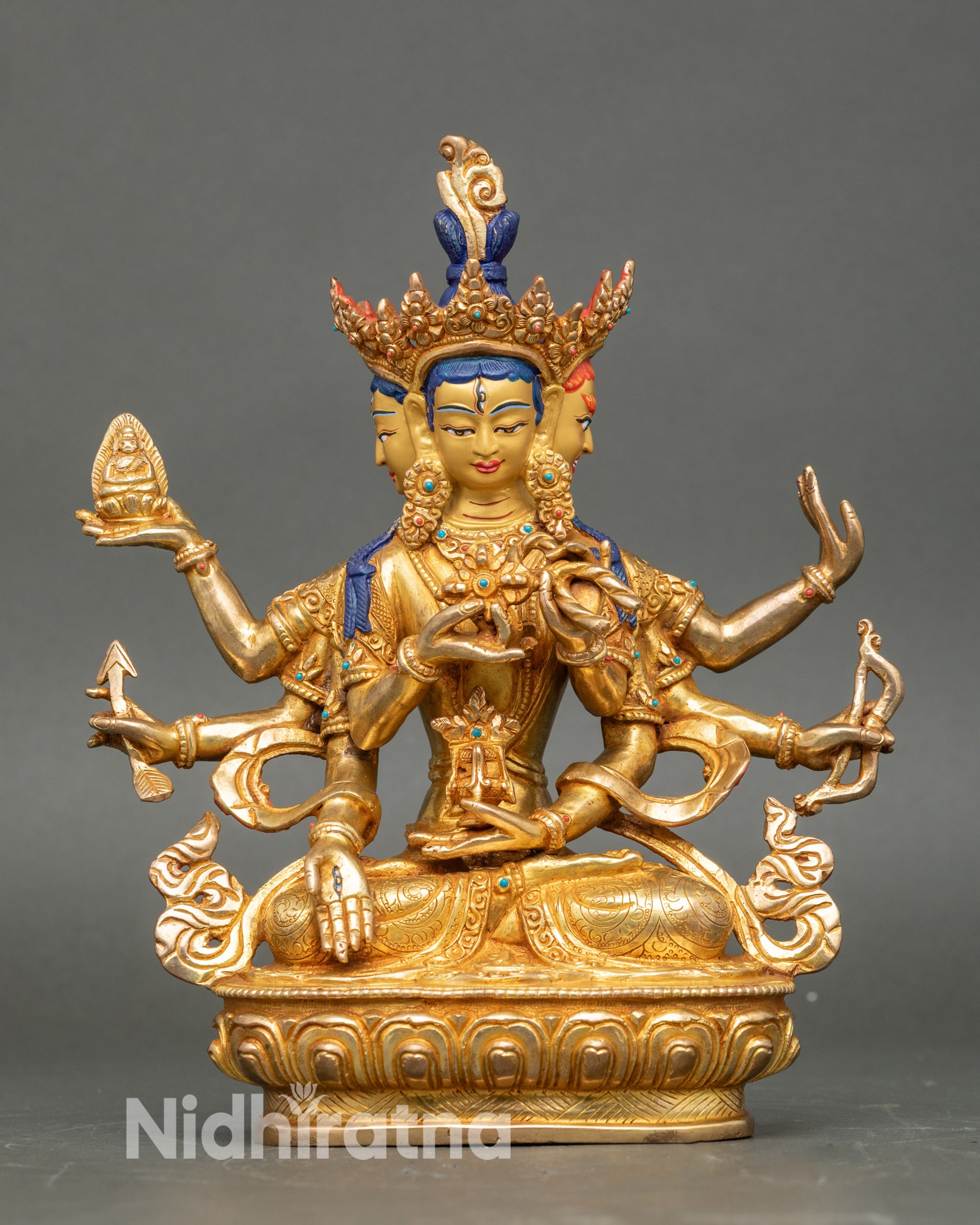 Front view Namgyalma statue, radiant gold with semi-precious stones, three faces, eight arms