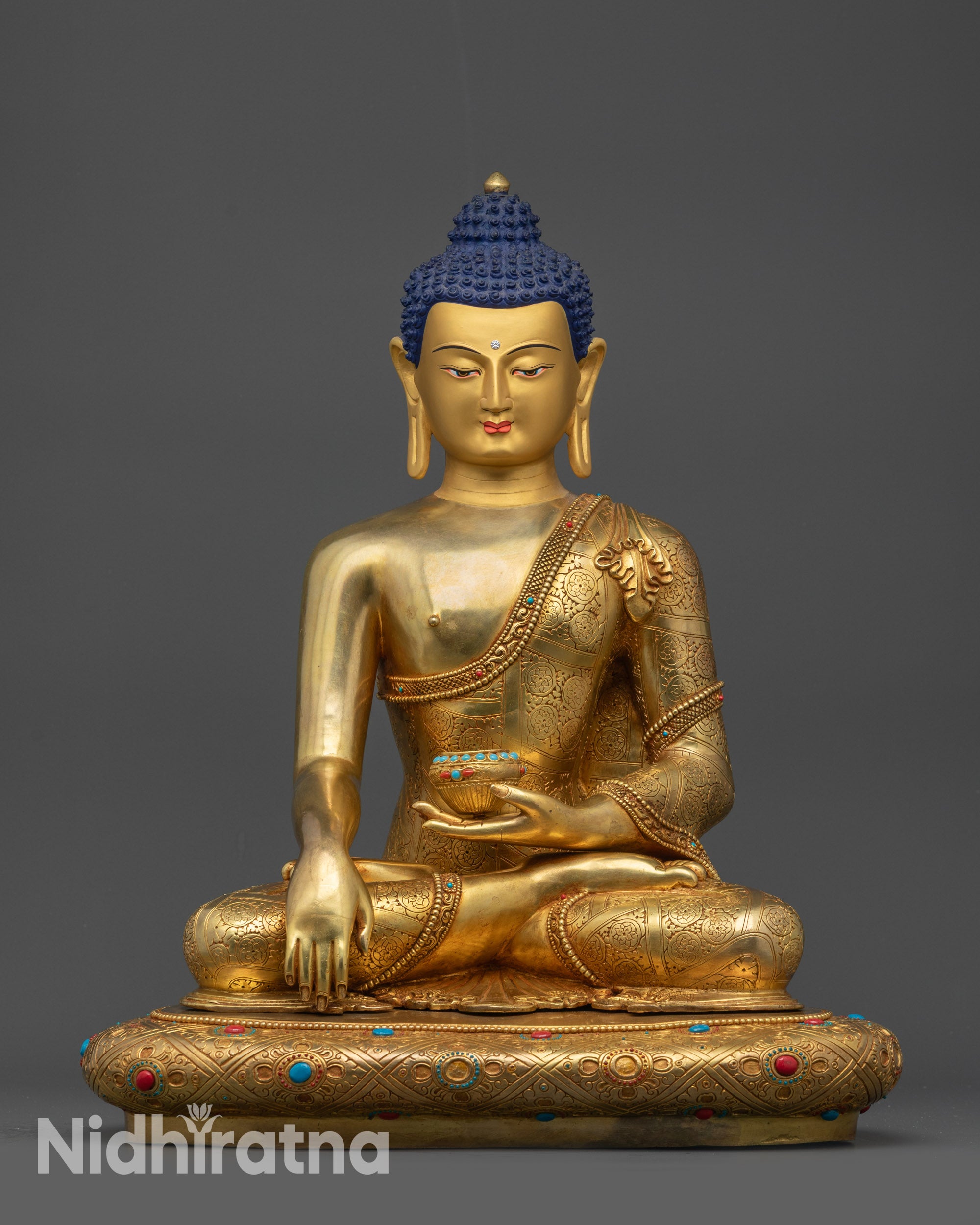 Front view Shakyamuni Buddha statue on lotus with gold-gilded face and patra bowl