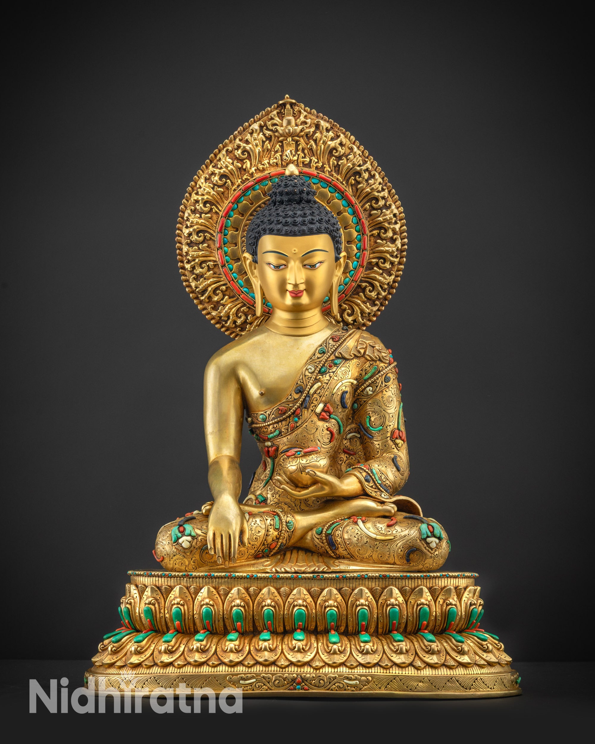 Front view Shakyamuni Buddha statue with gold gilded face and serene expression