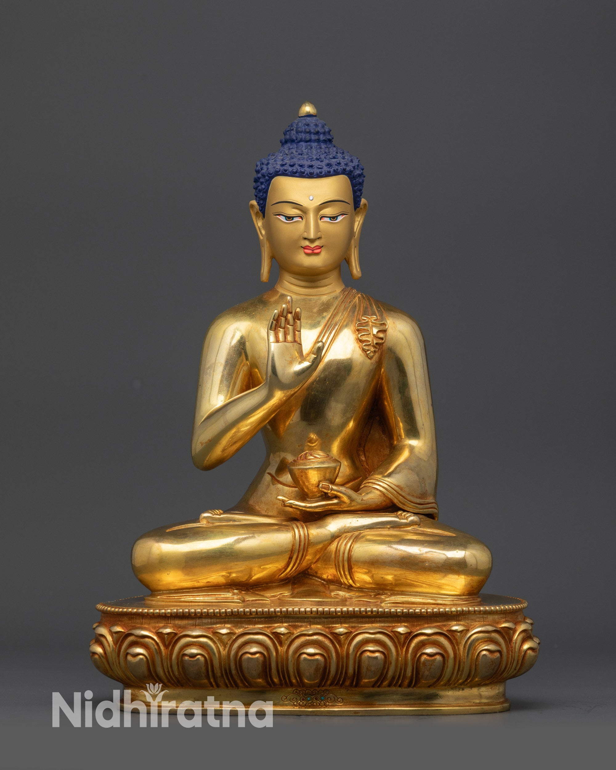 Front view of Amoghasiddhi Buddha statue on lotus pedestal with gold-gilded face