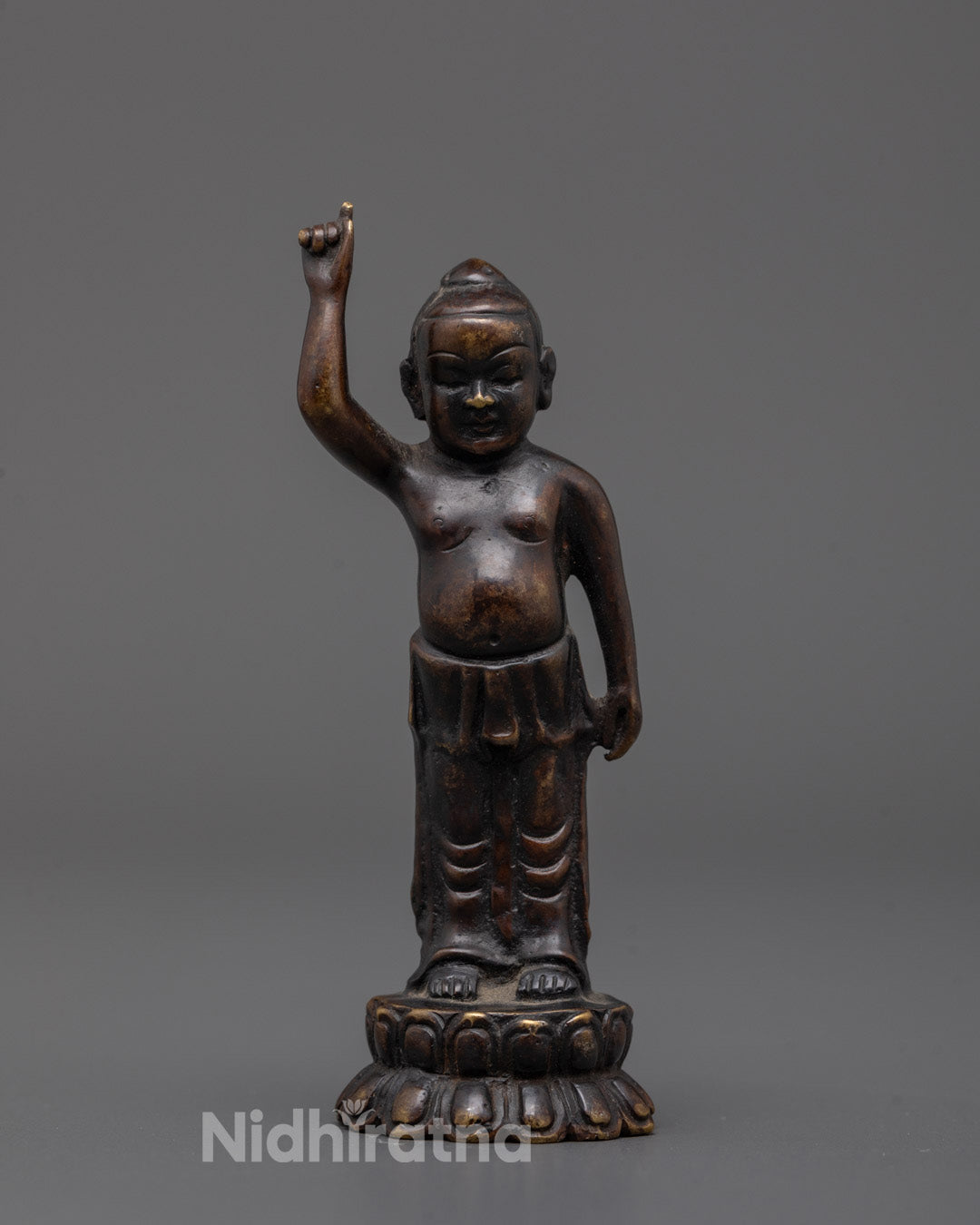 Front view of Baby Buddha statue on lotus seat with oxidized copper finish