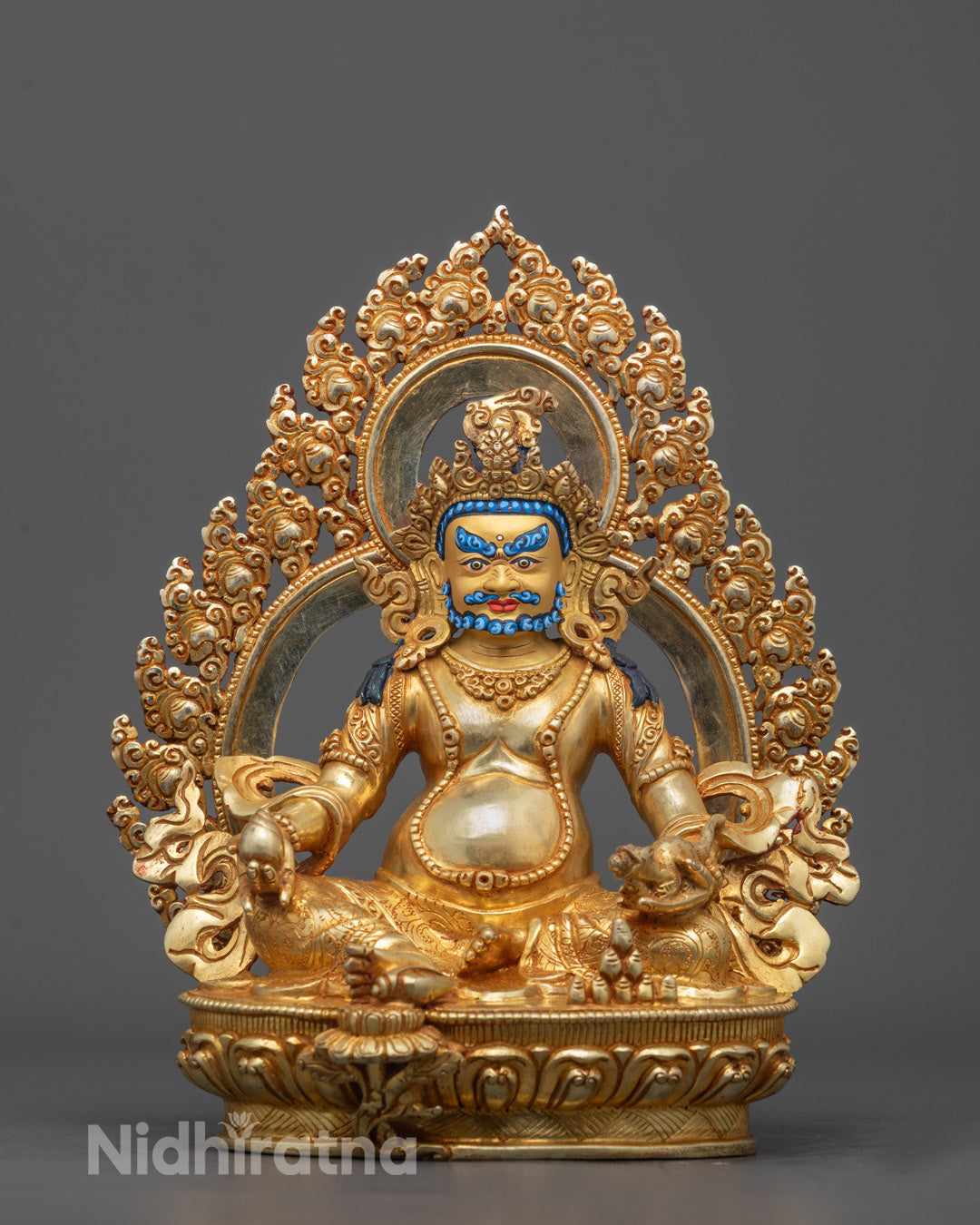 Front view of Dzambhala sculpture with gold-gilded face and jewelry-spitting mongoose
