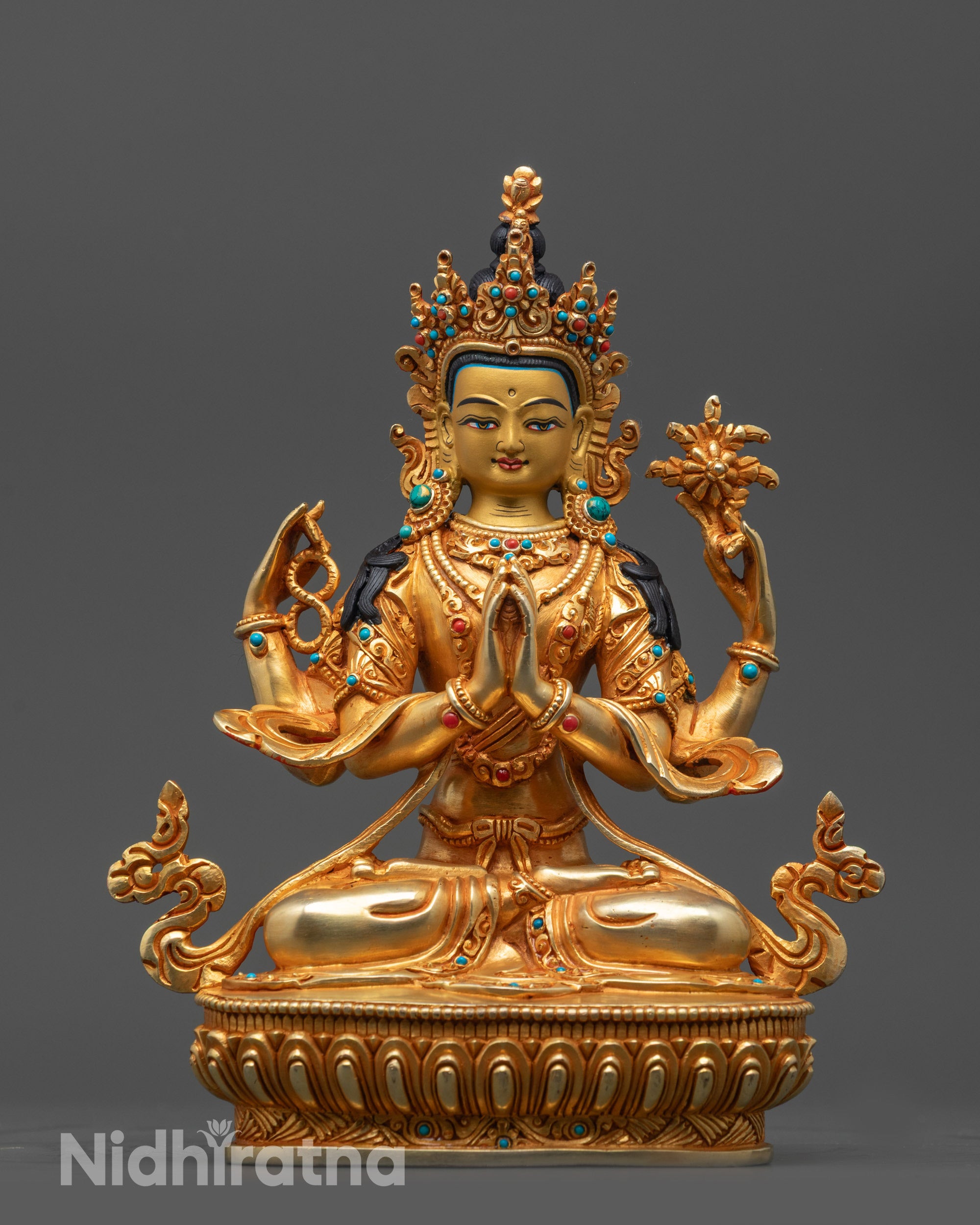 Front view of Four-Armed Avalokiteshvara statue with gold-gilded face and sacred objects