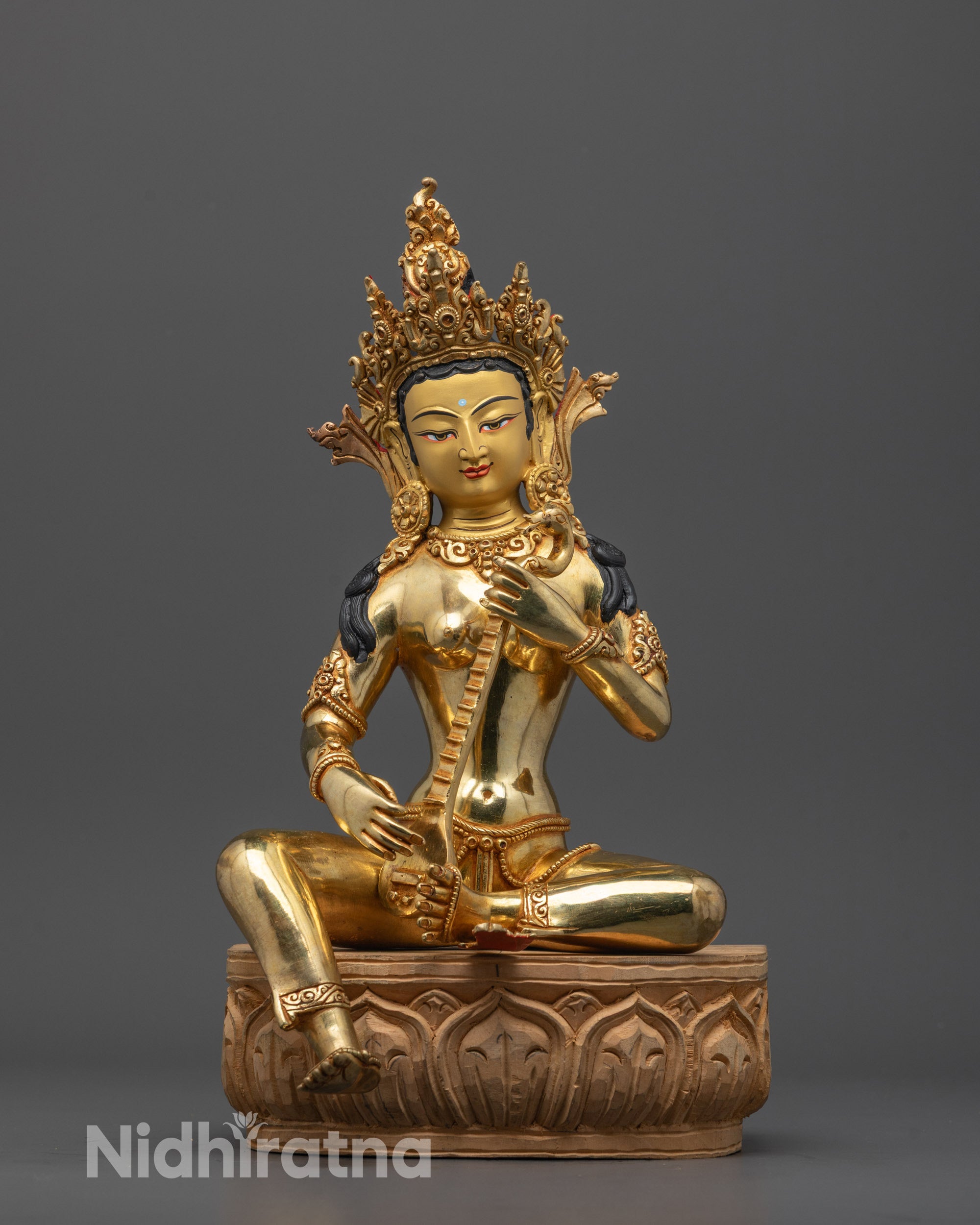 Front view of Goddess Saraswati statue with 24K gold-gilded face and veena on wooden base