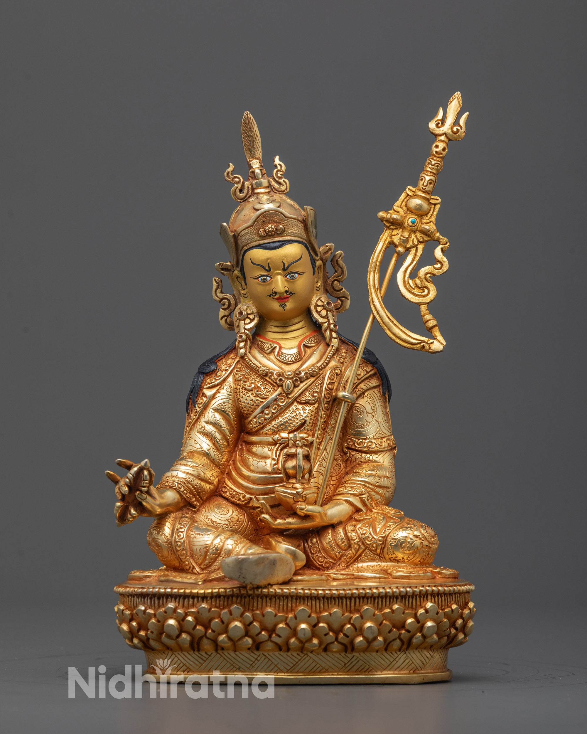 Front view of Guru Rinpoche Statue seated on lotus base holding vajra and skull cup with vase