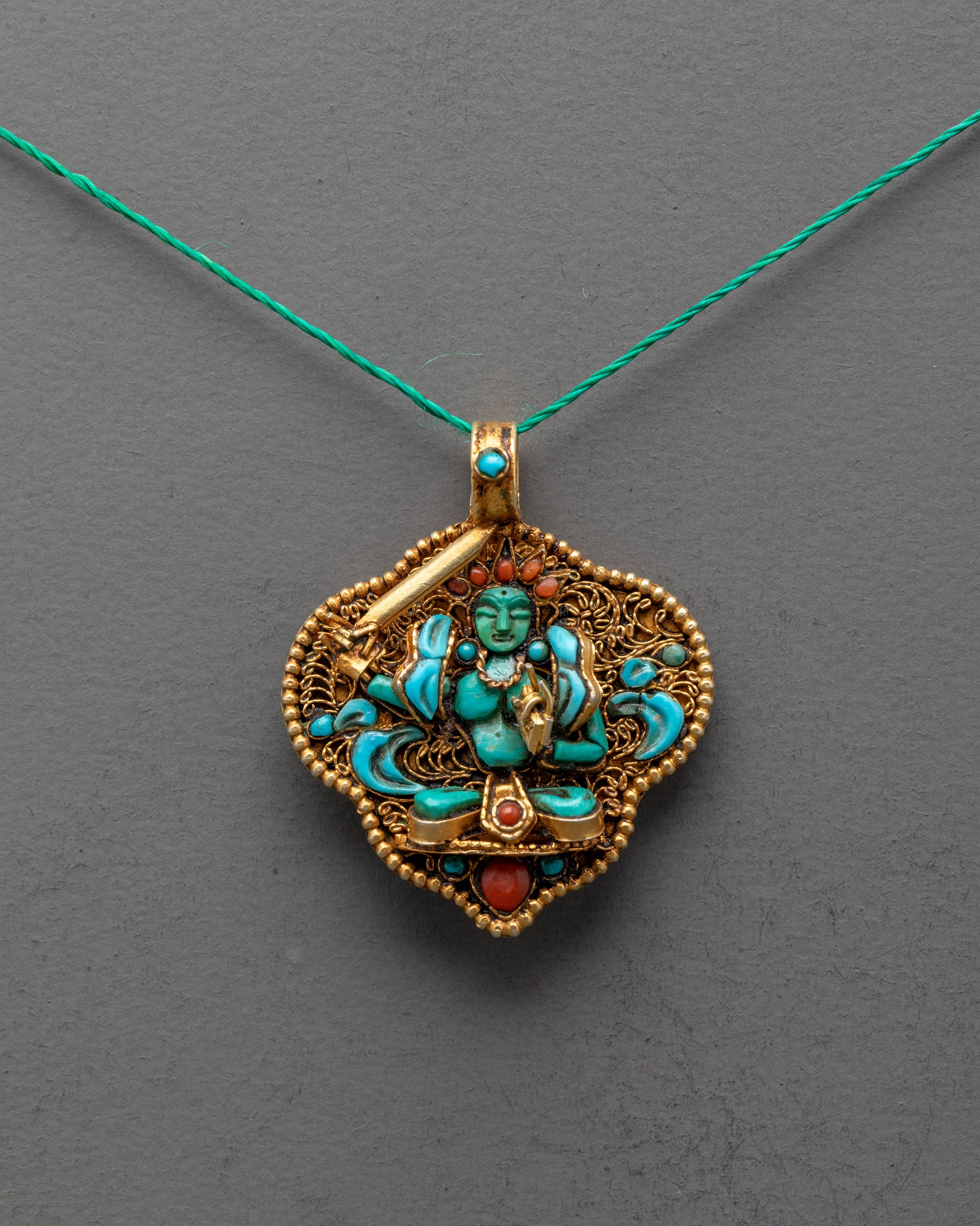 Front view of Handmade Manjushri Locket featuring radiant green crystal and gold-gilded filigree, crafted by master artisans from Patan, Nepal.