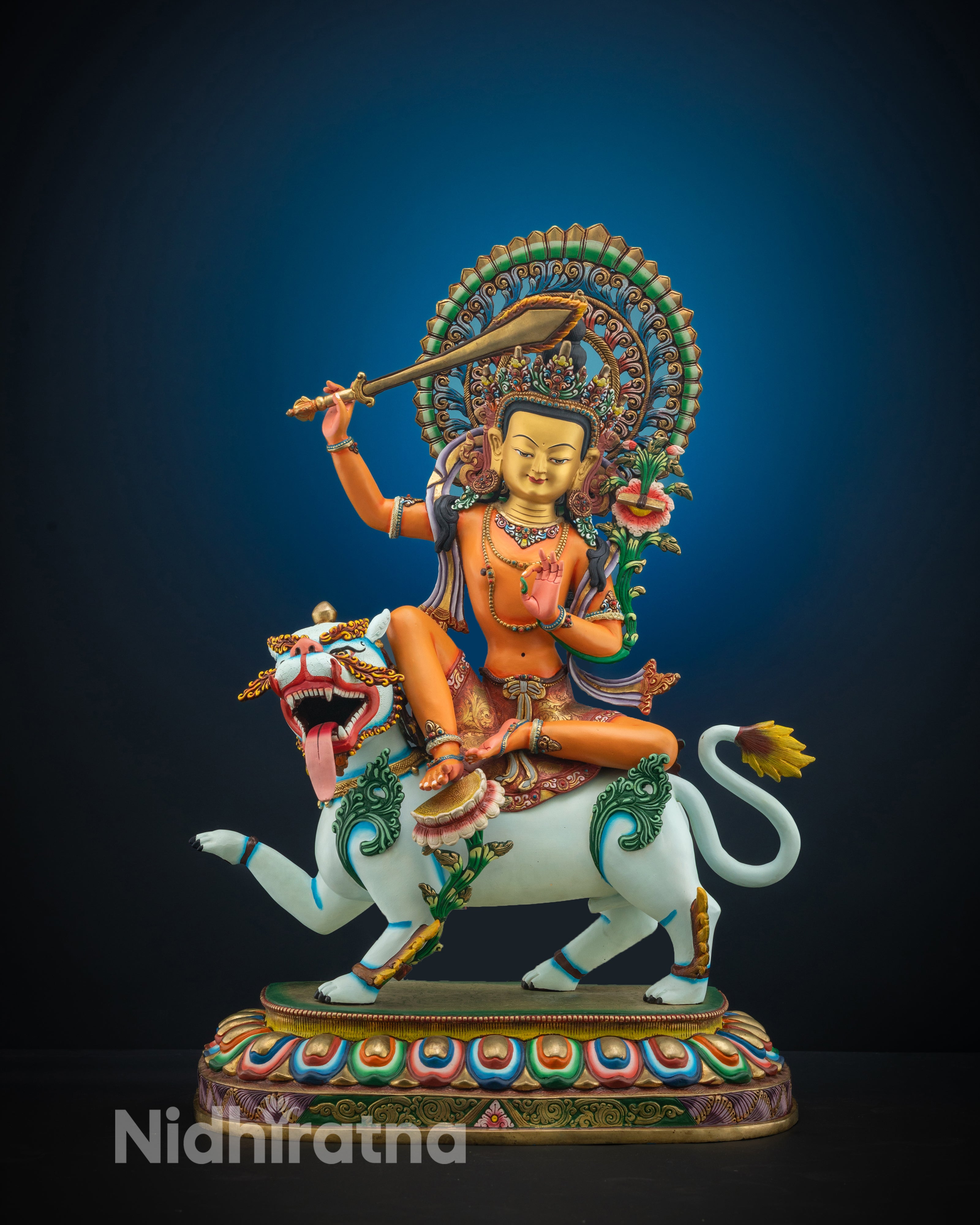 Front view of Manjushri Statue seated on lion with gold face and orange-accented body