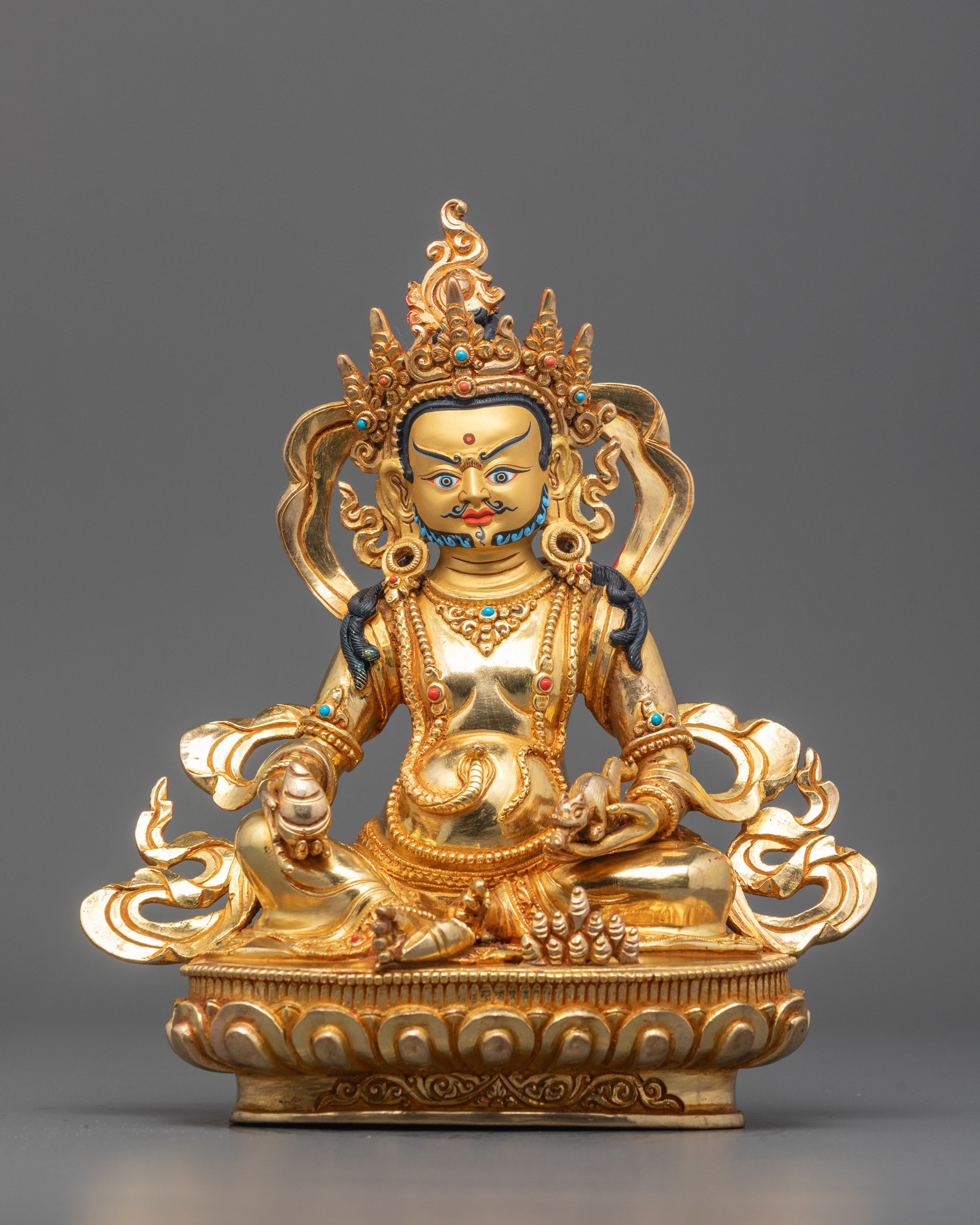 Front view of Traditional Dzambhala Statue with gold-gilded face and lotus throne