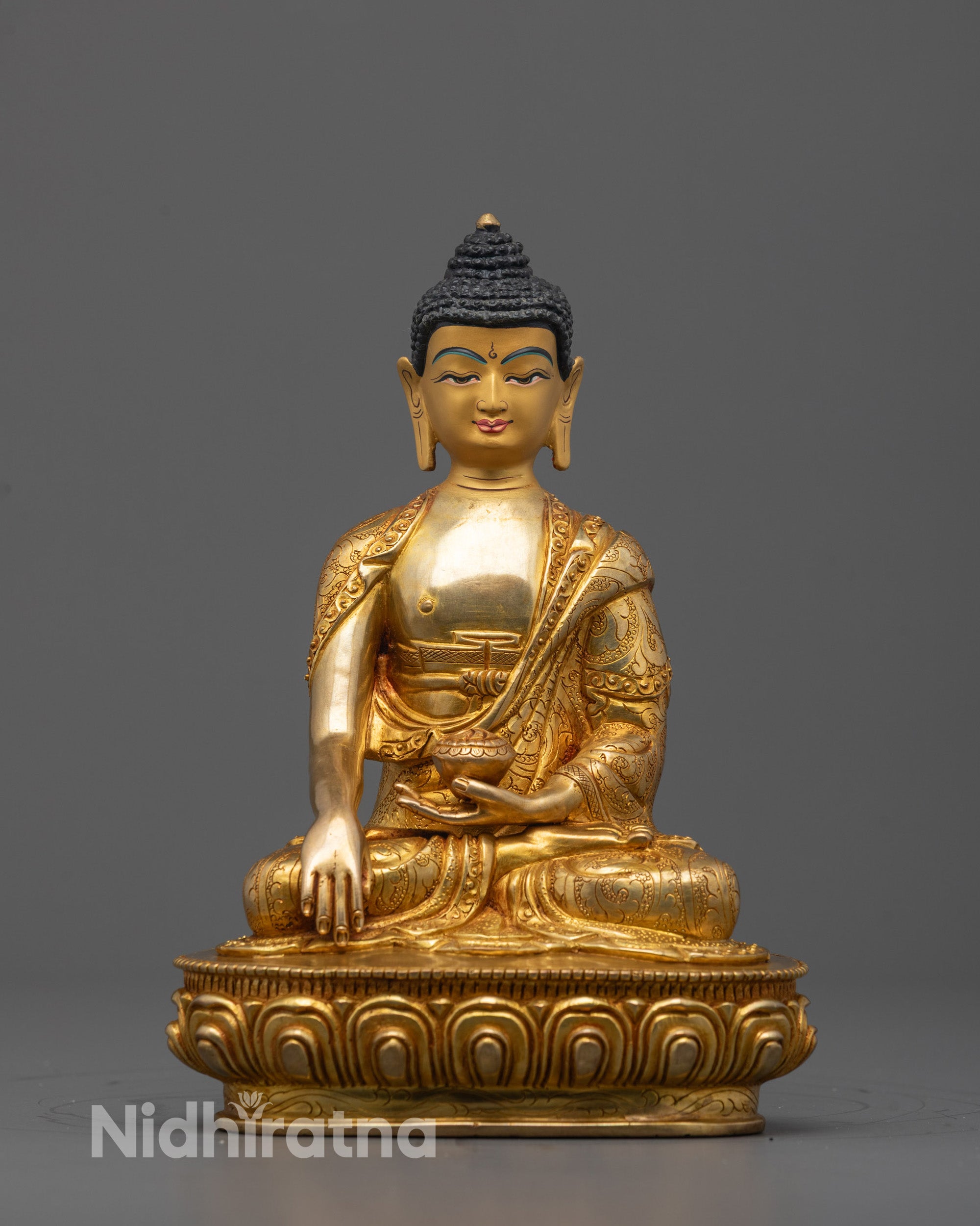 Front view of hand-carved Buddha Shakyamuni Statue seated on a lotus base holding a monk’s bowl