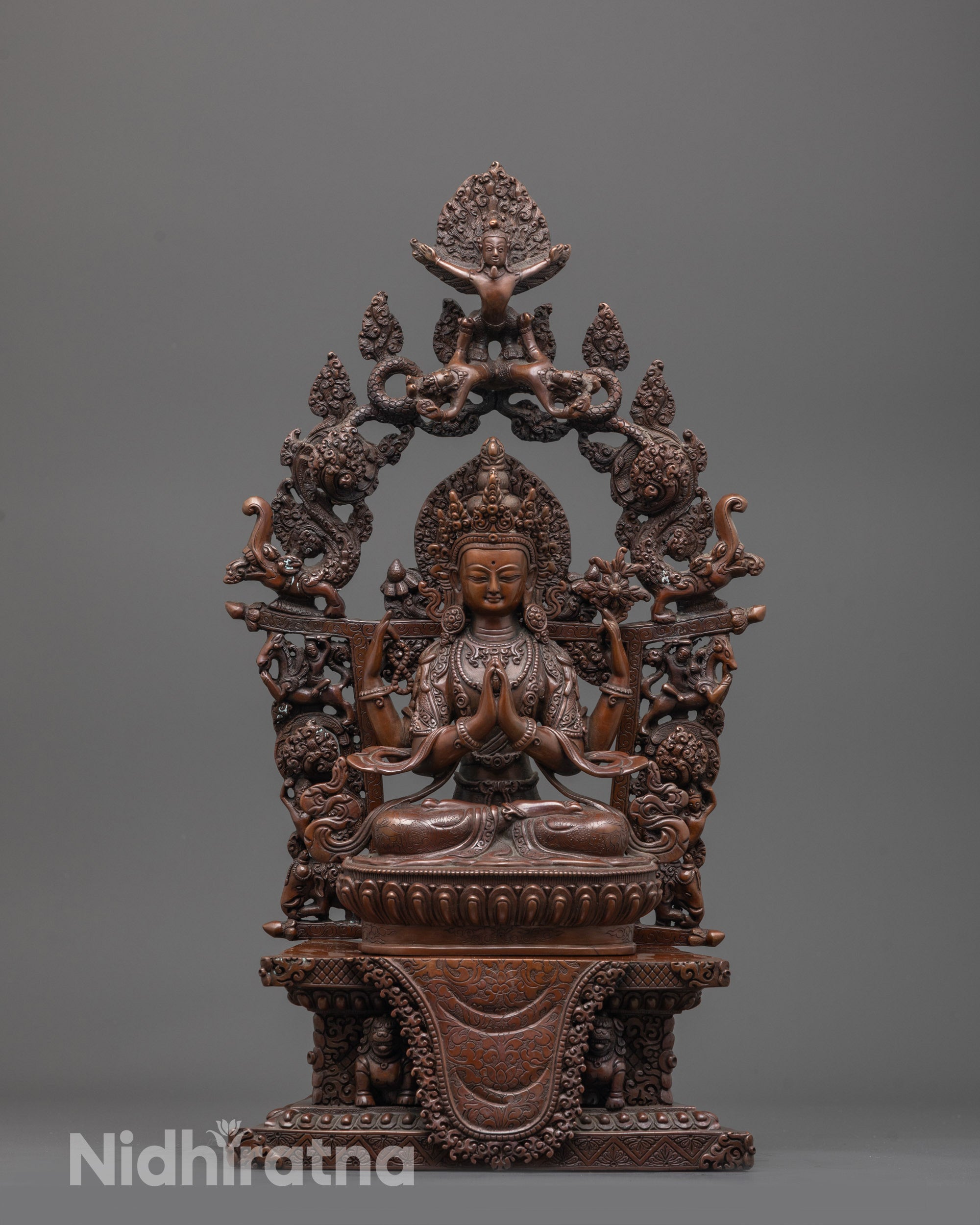 Front view of hand-carved Chenrezig Statue in oxidized copper seated on a lotus throne