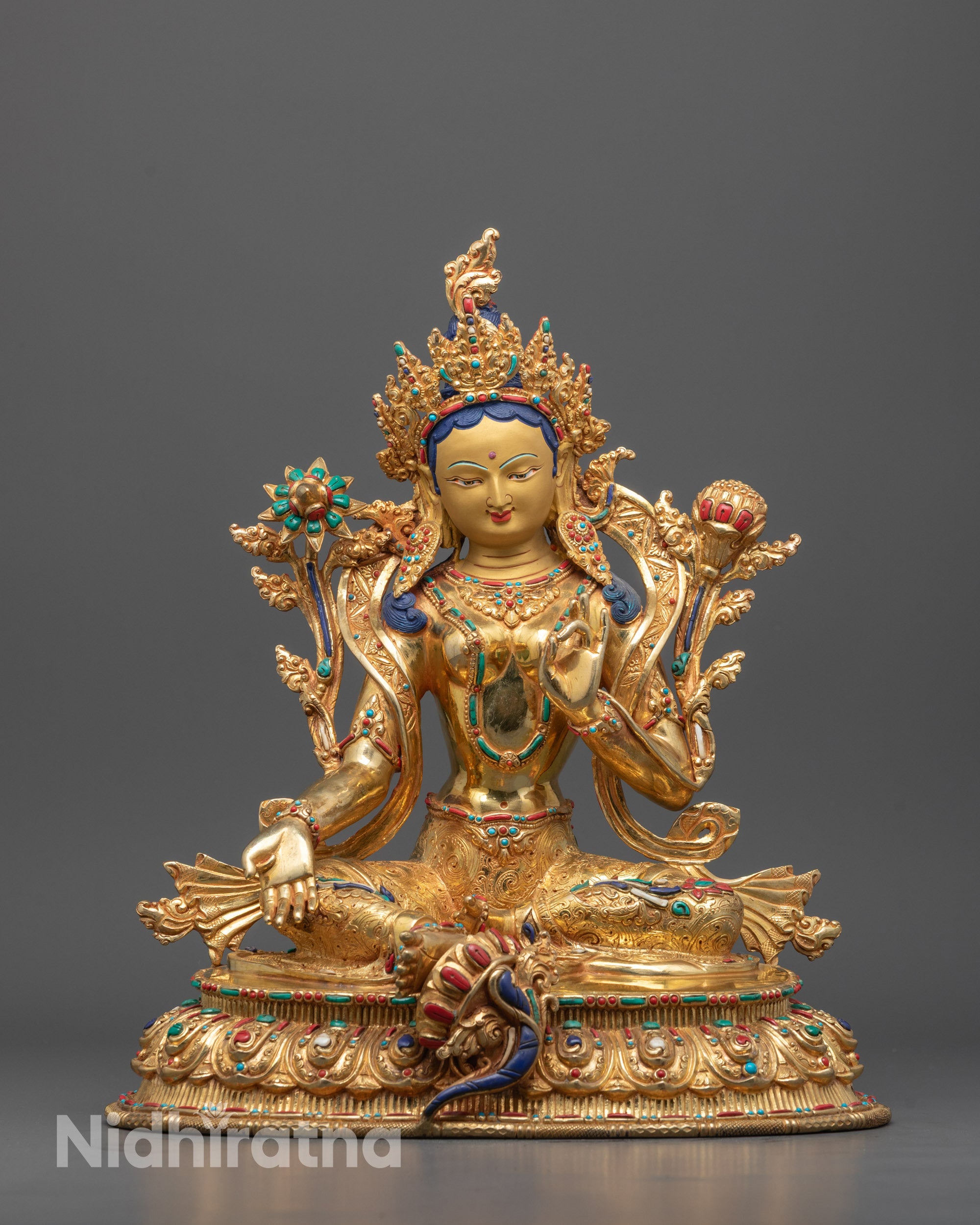 Front view of hand-carved Green Tara Statue seated on a lotus throne with calm expression