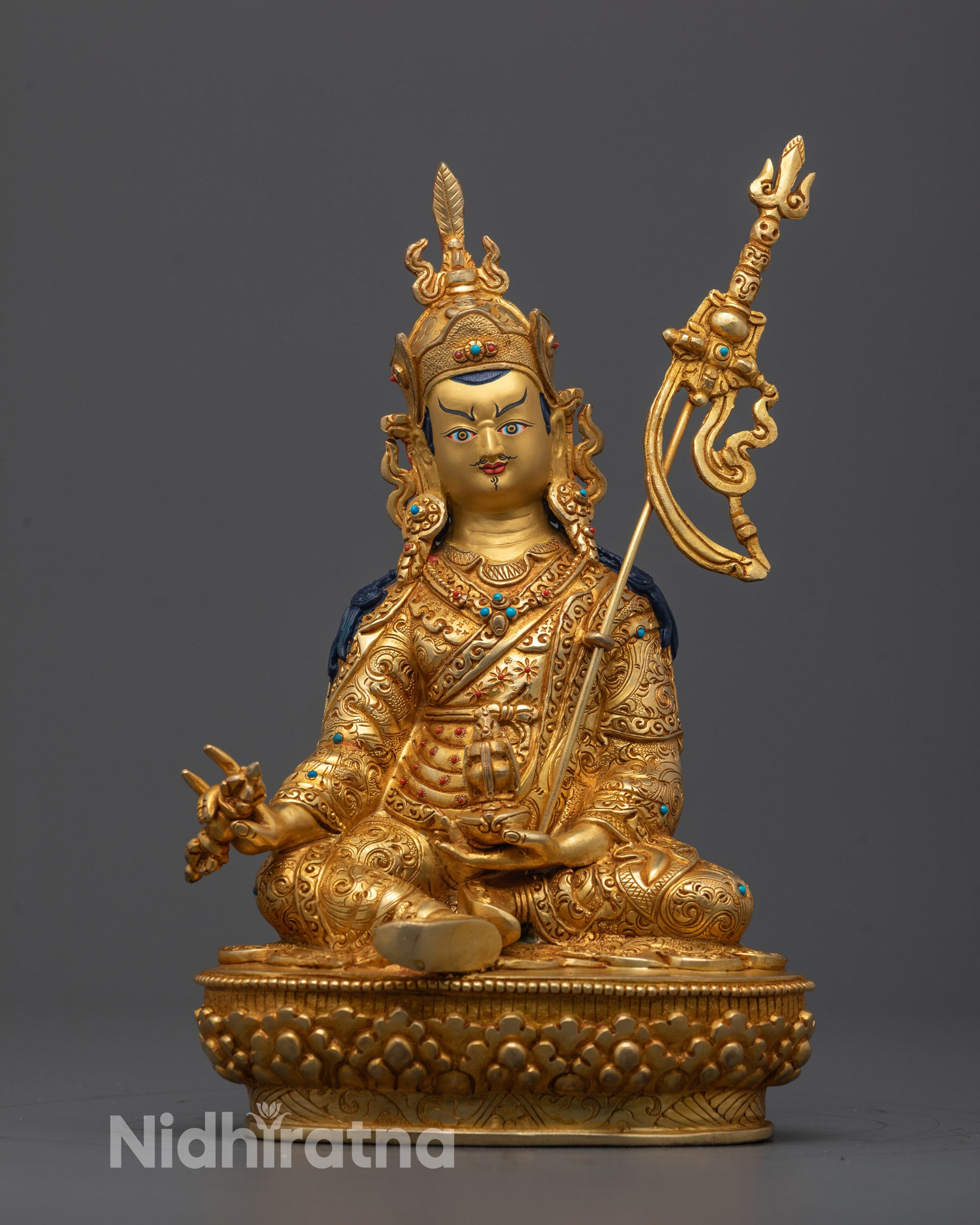 Front view of hand-carved Guru Rinpoche Statue seated on a lotus base holding a skull cup