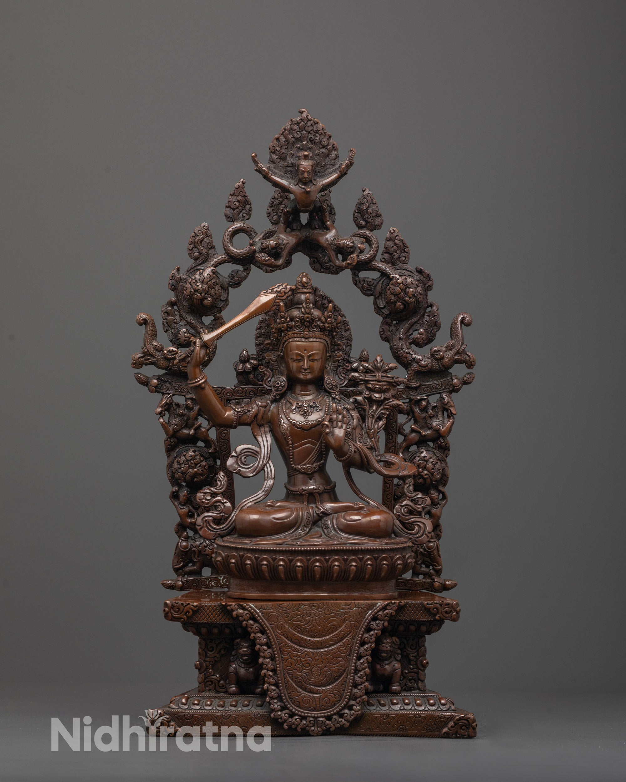 Front view of handcrafted Manjushri statue with oxidized copper and detailed lotus throne