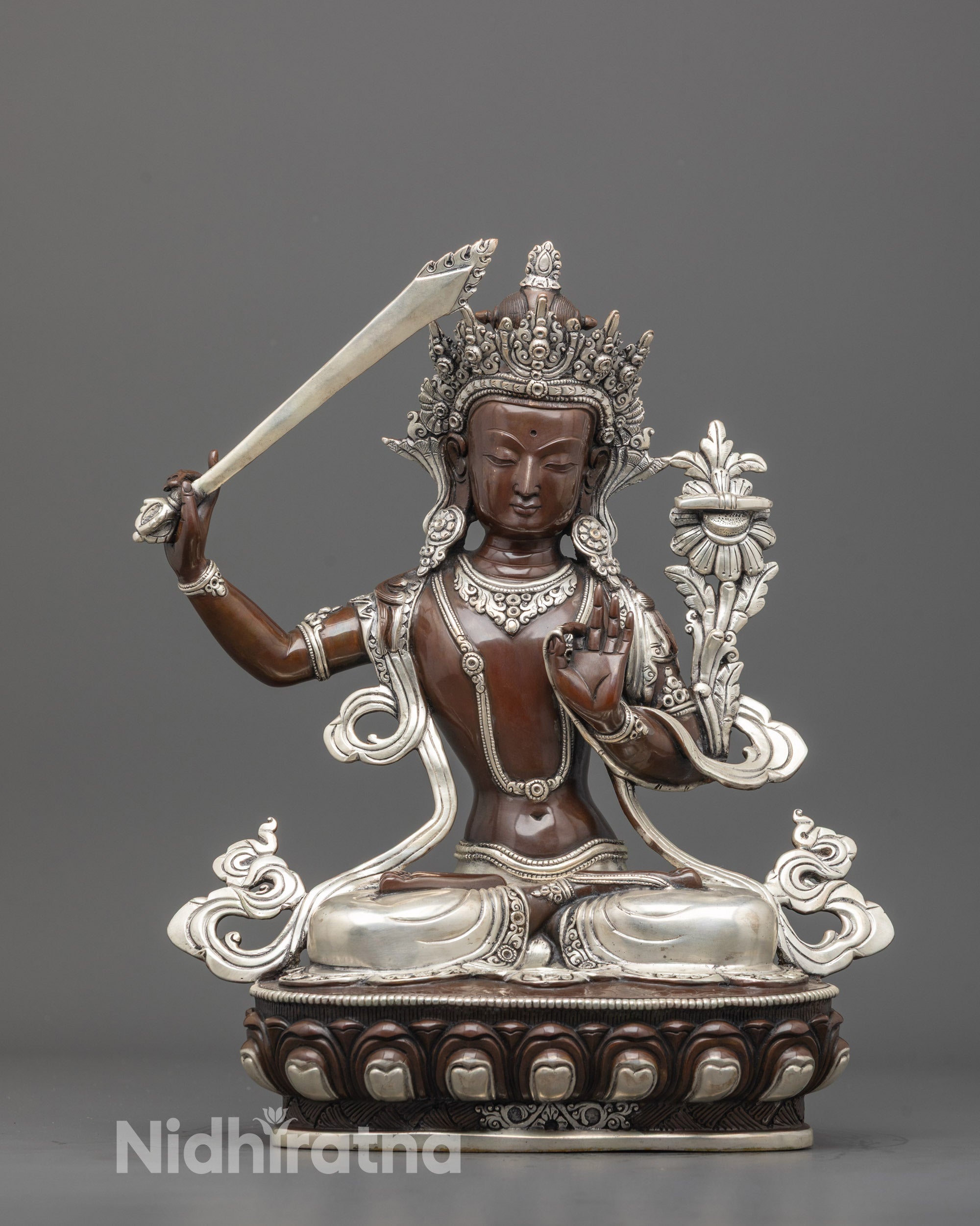 Front view of handcrafted Manjushri statue with silver details and lotus seat