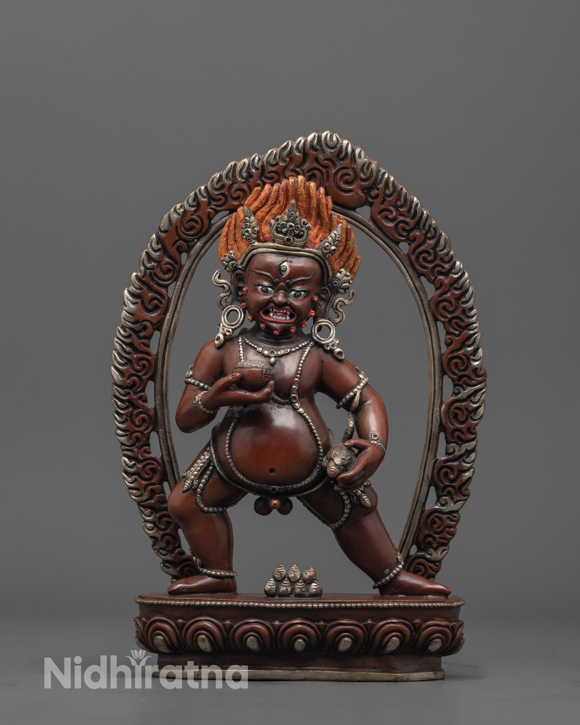 Front view of oxidized black Dzambhala statue with silver crown holding mongoose, wealth deity
