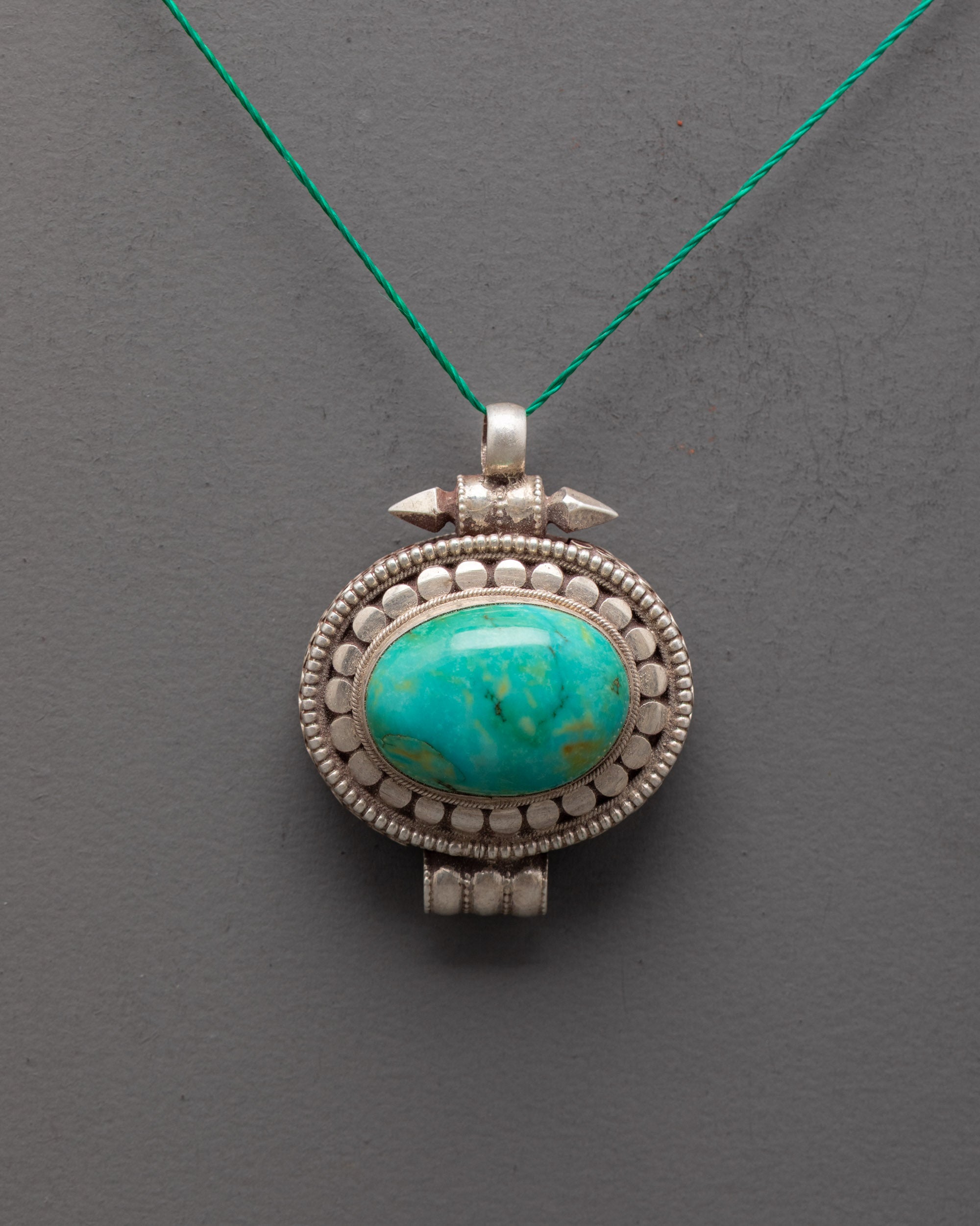Front view of silver turquoise locket with oval stone, handcrafted by Himalayan artisans