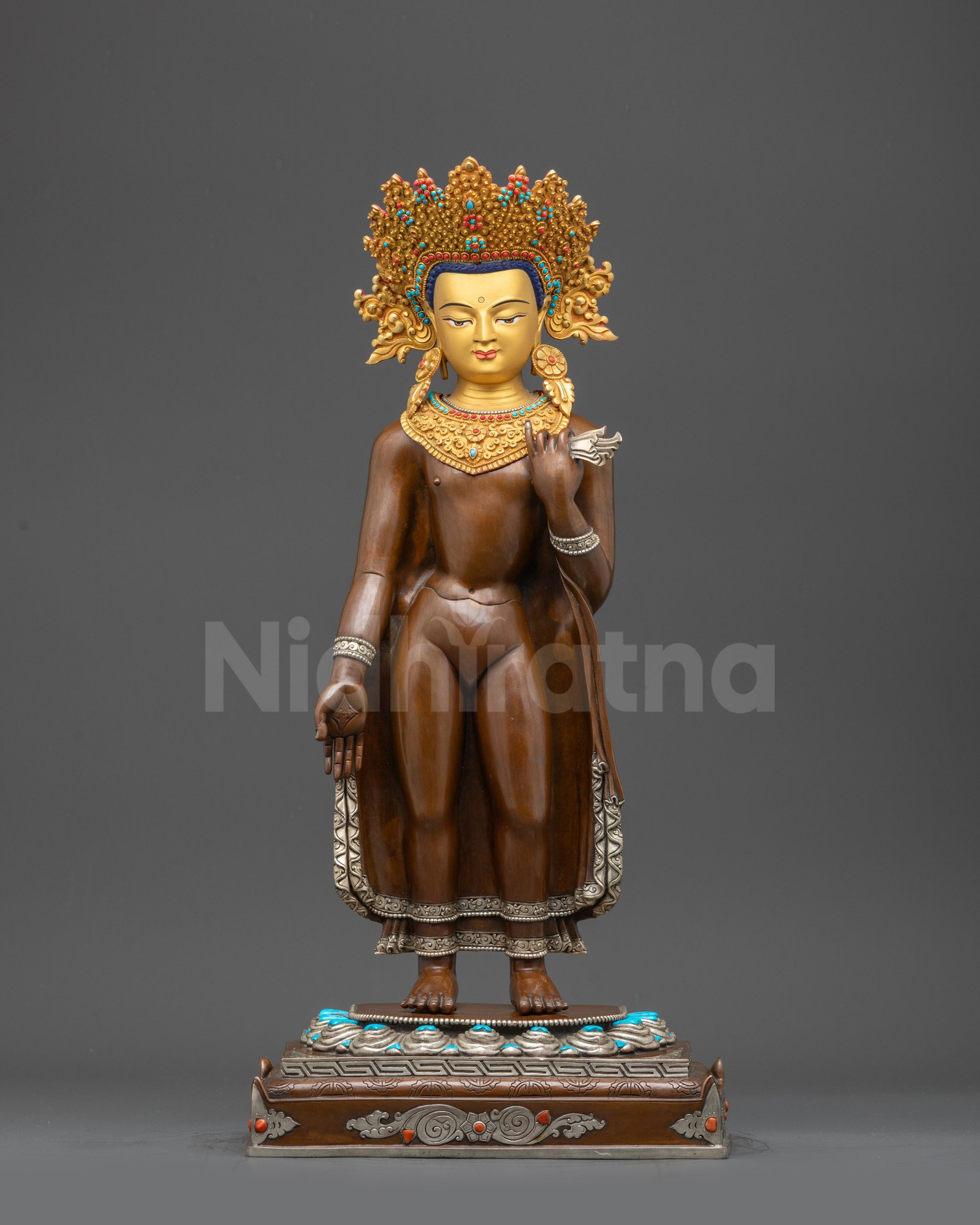Front view of standing Dipankara Buddha statue on lotus with gold-gilded face