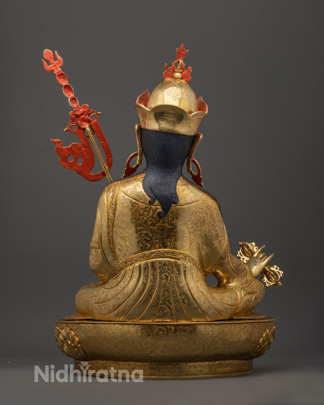 Guru Rinpoche statue holding Vajra and skull cup, adorned in colorful acrylics and 24k gilded copper, symbolizing wisdom and compassion.
