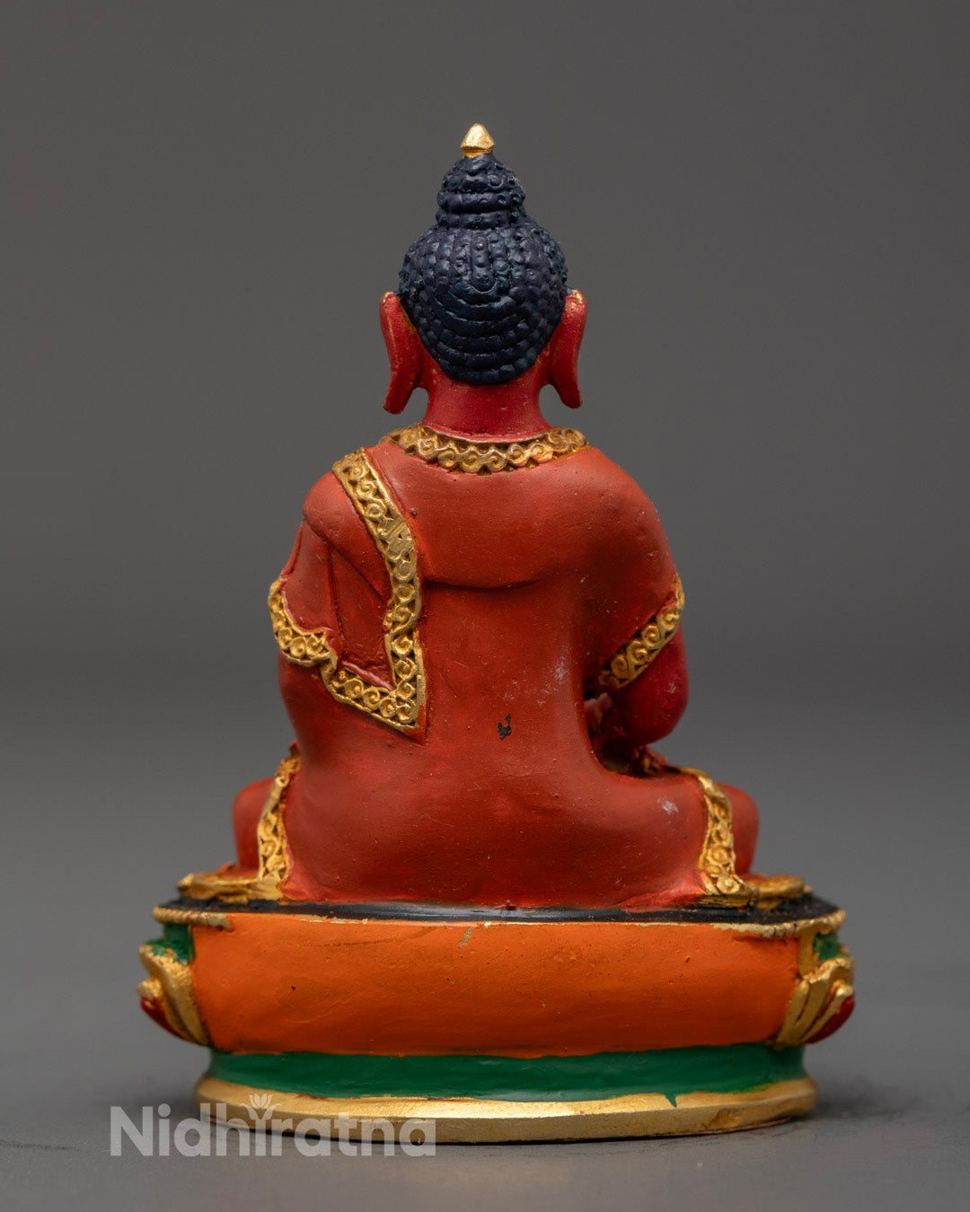 Amitabha Buddha statue displaying calm posture and spiritual elegance in red tones