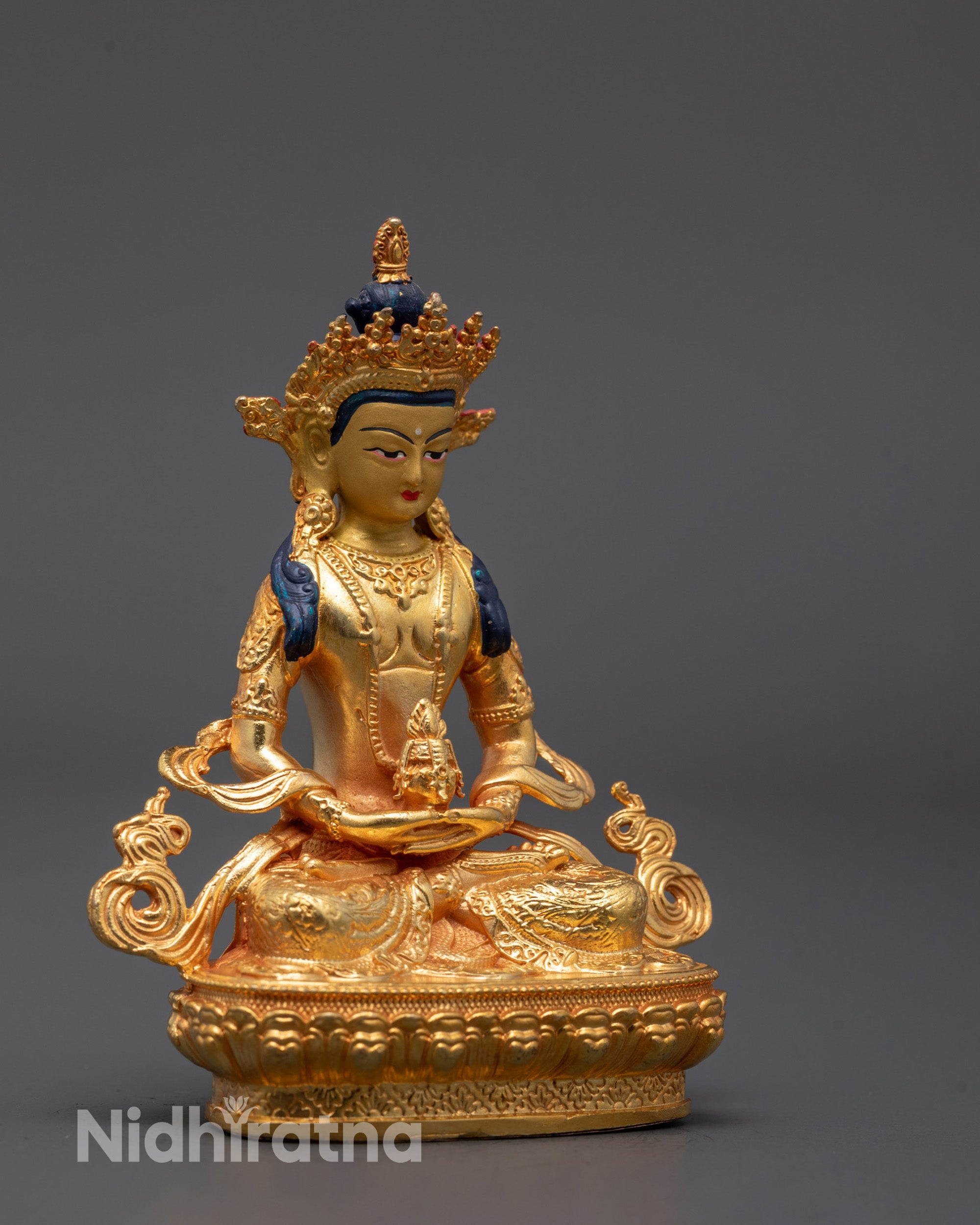 Full view of golden Amitayus Statue sitting on a lotus seat, symbolizing longevity