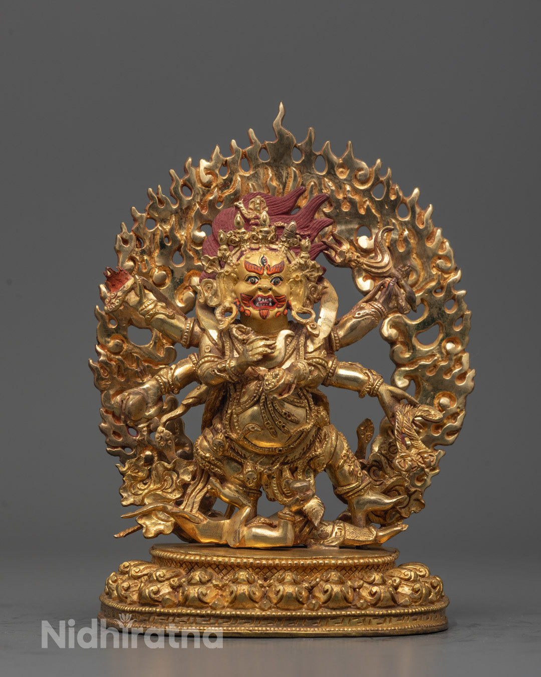 Full view of the Six Armed Mahakala Statue standing on a lotus seat with two subdued deities