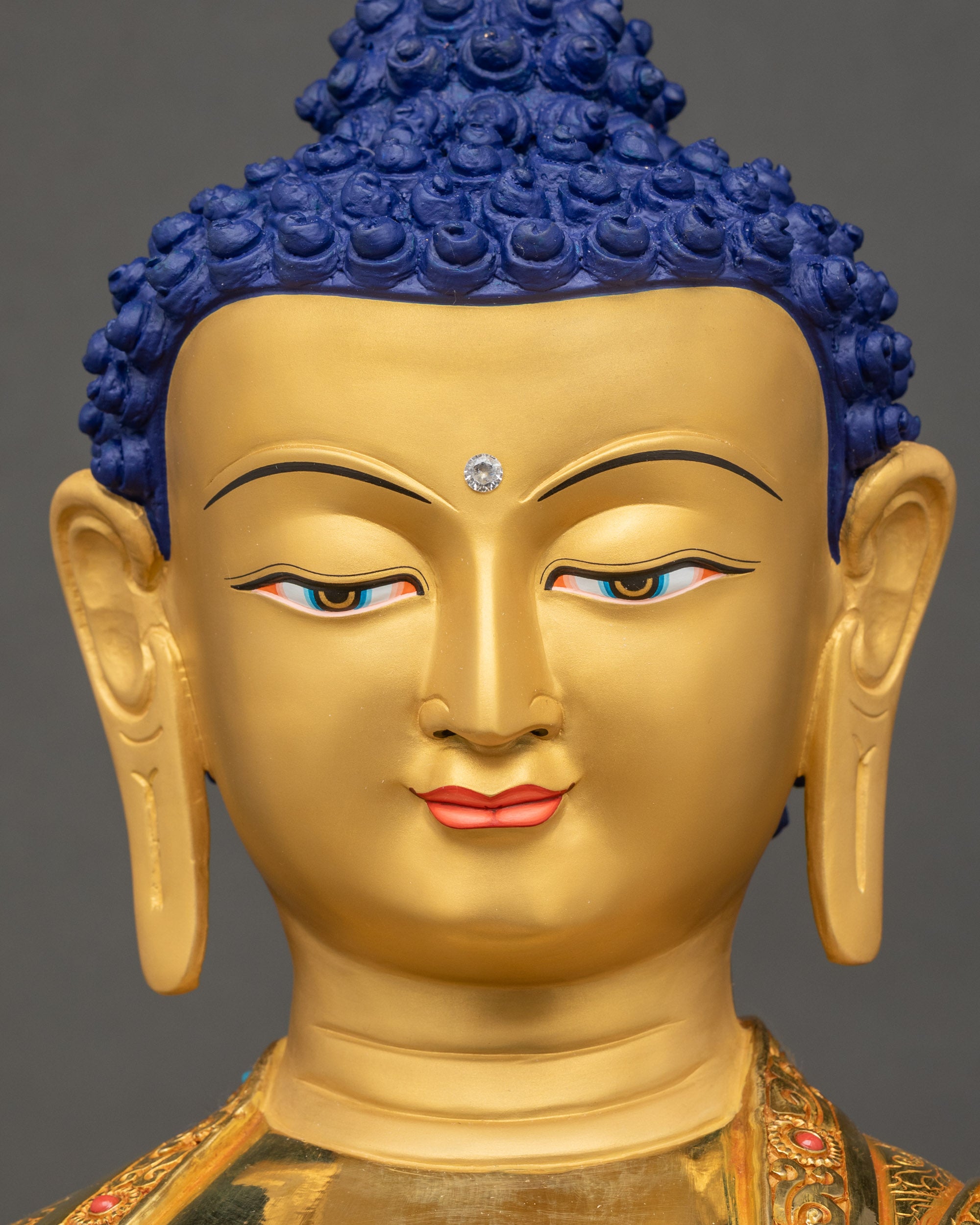 Gold-painted face of Shakyamuni Buddha Statue with serene expression and radiant detailing