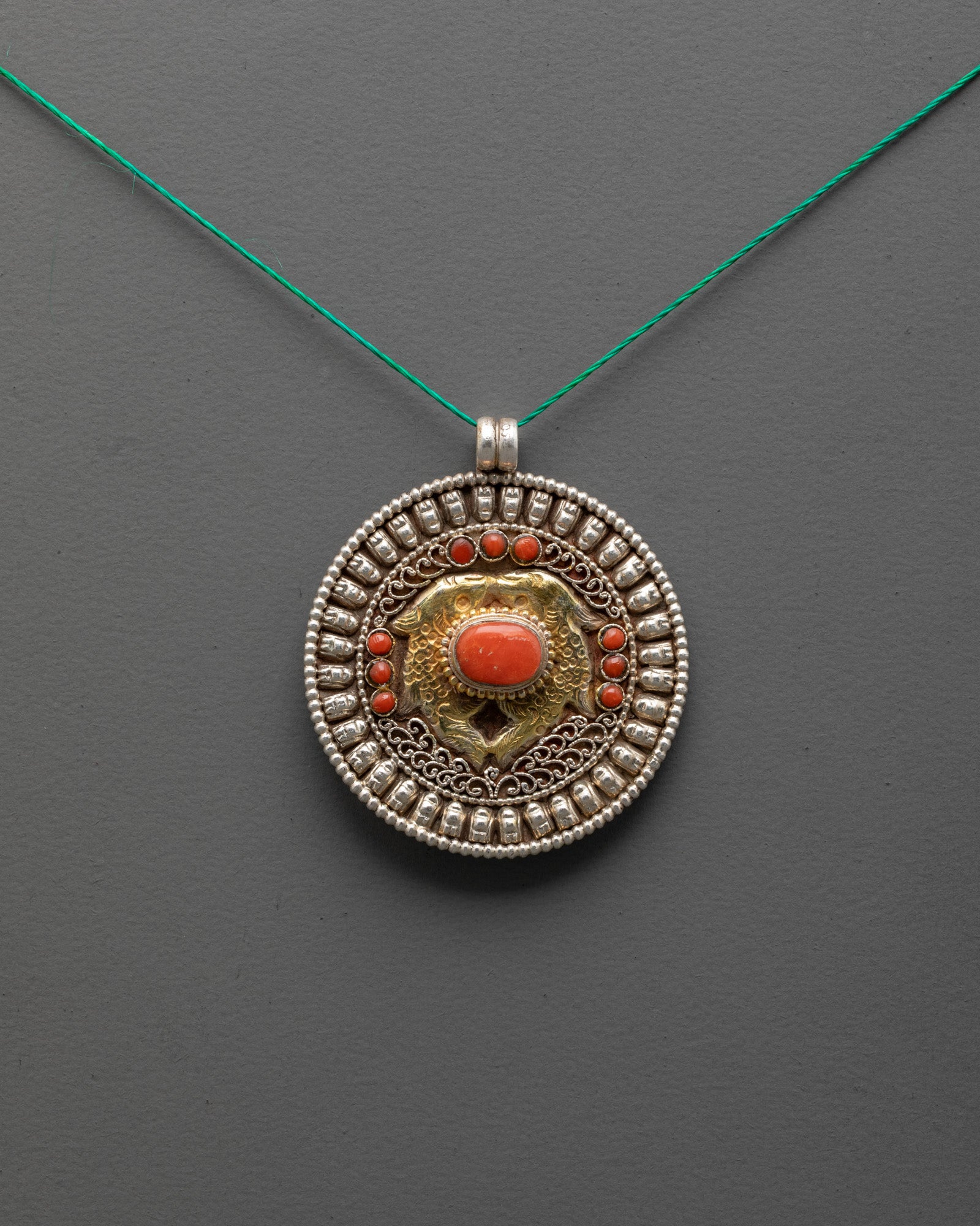 Golden Fish Locket front view with gold-gilded fish and coral stones