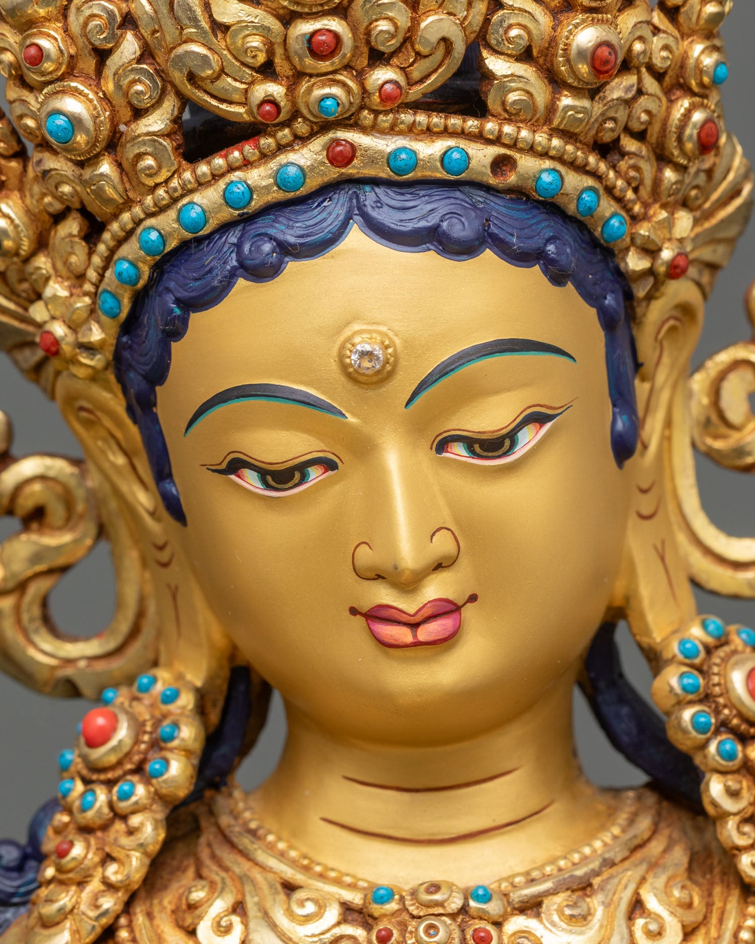 Green Tara Bodhisattva, serene gold-painted face, turquoise and coral