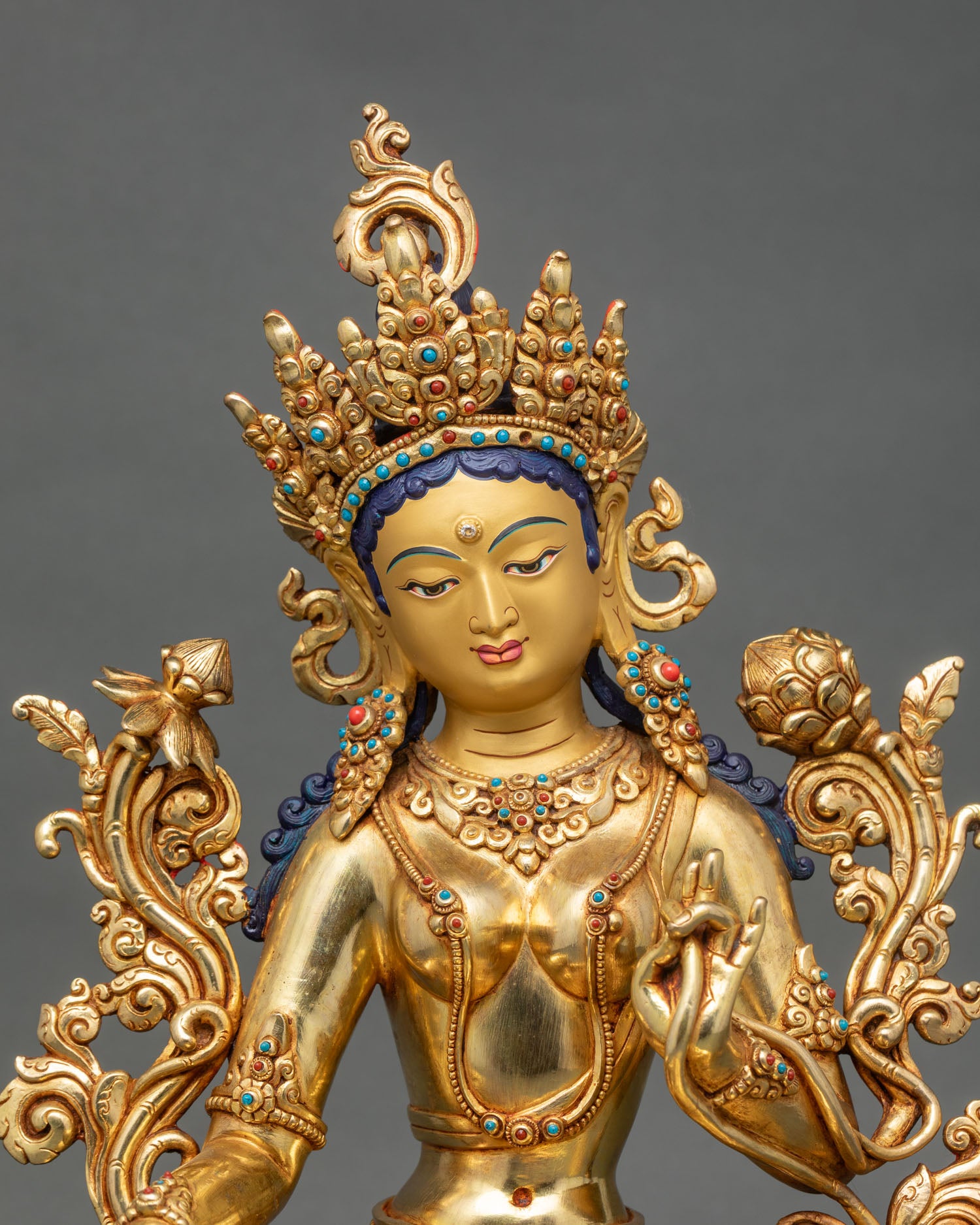 Green Tara Drolma statue showing intricate gold fire-gilded details