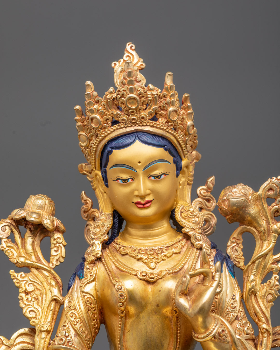 Mother Green Tara’s serene gold-gilded face and intricately carved crown – symbolizing compassion and divine protection