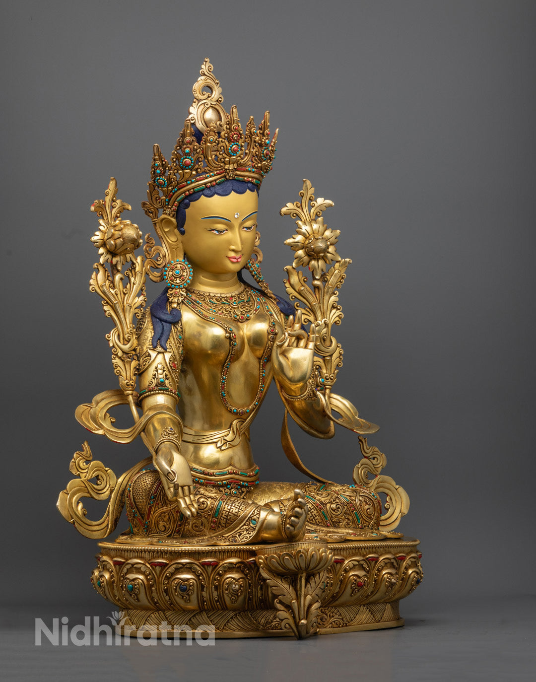 Green Tara sculpture, highlighting ornate craftsmanship, symbolic ornaments, and the consecration chamber at the base