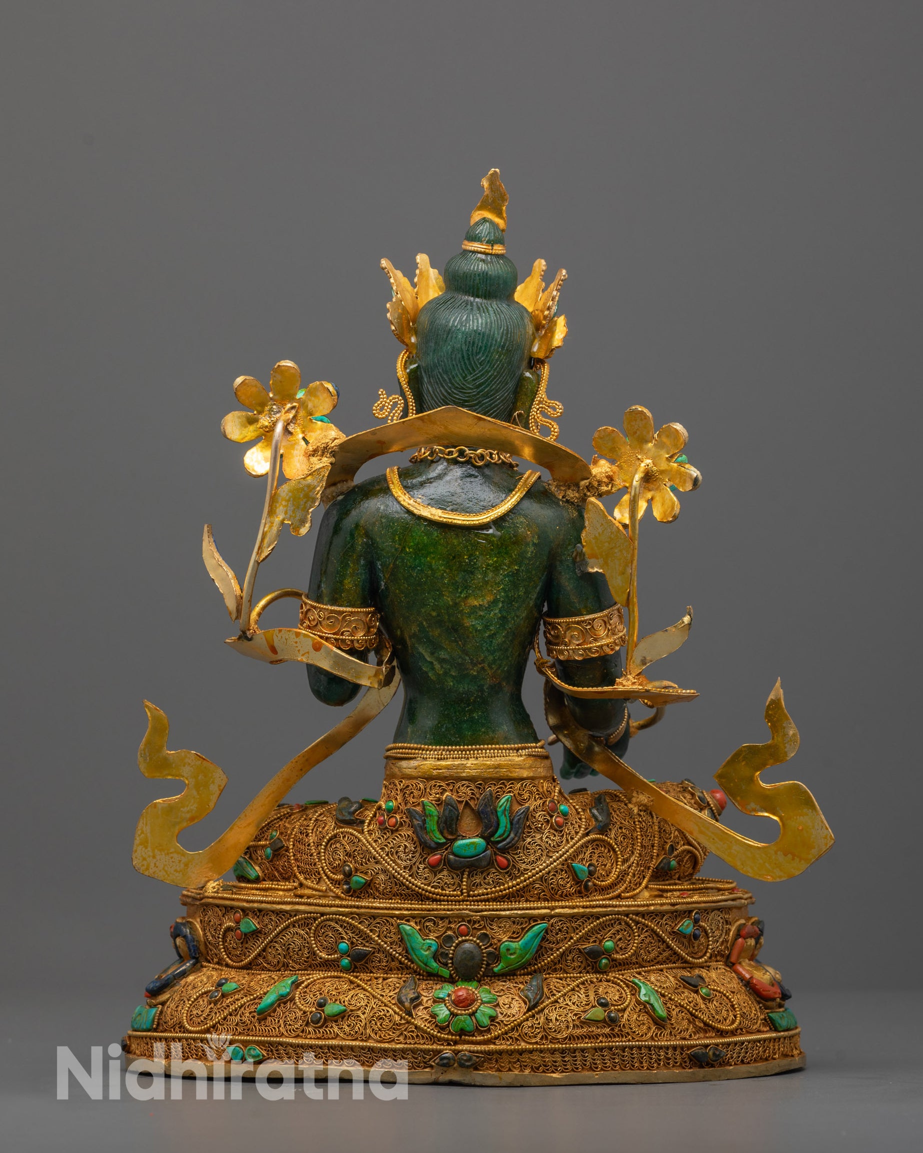 Green Tara and the craftsmanship of her lotus throne with symbolic gold filigree.