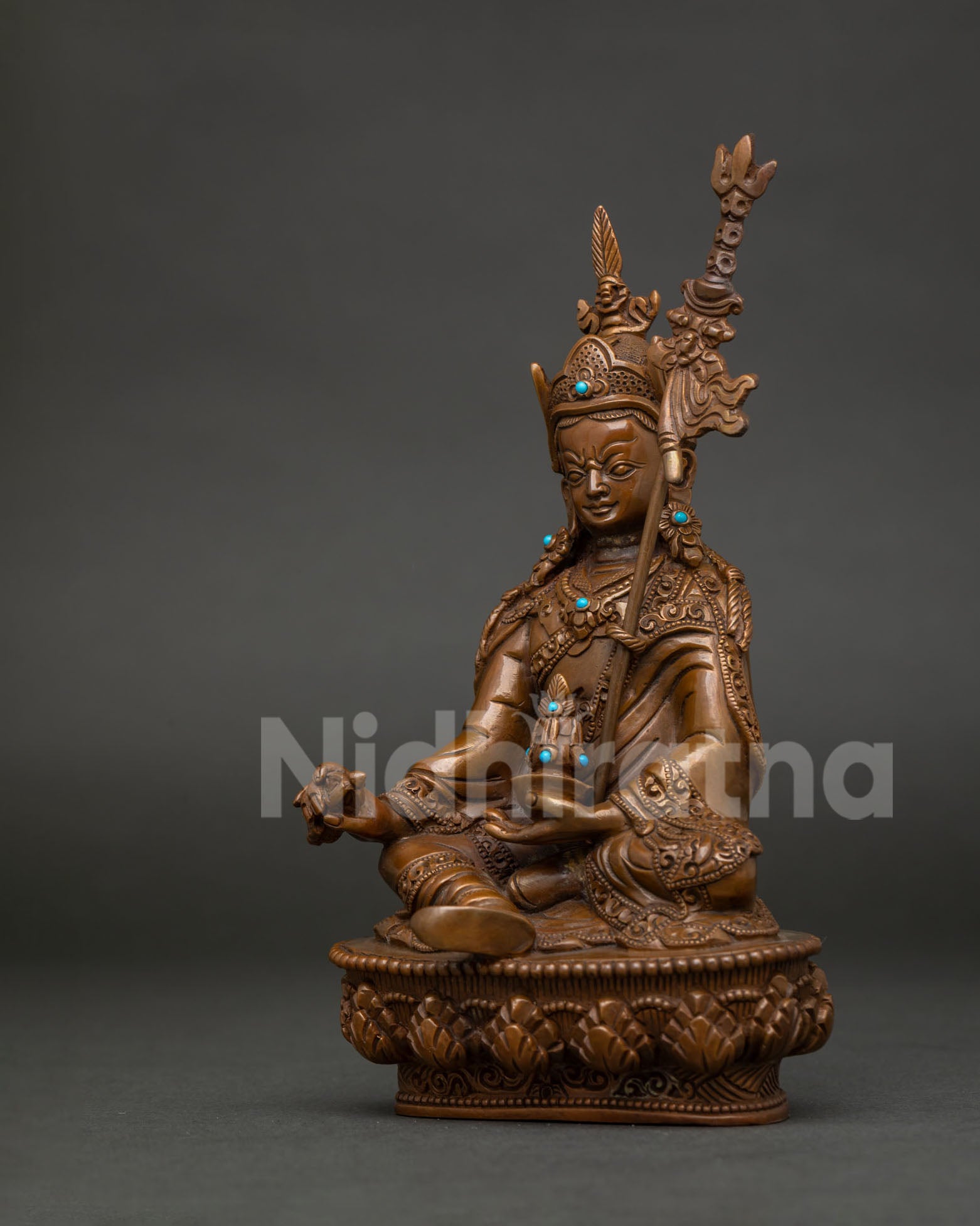 Guru Rinpoche Padmasambhava statue seated on hand carved lotus pedestal with khatvanga staff.