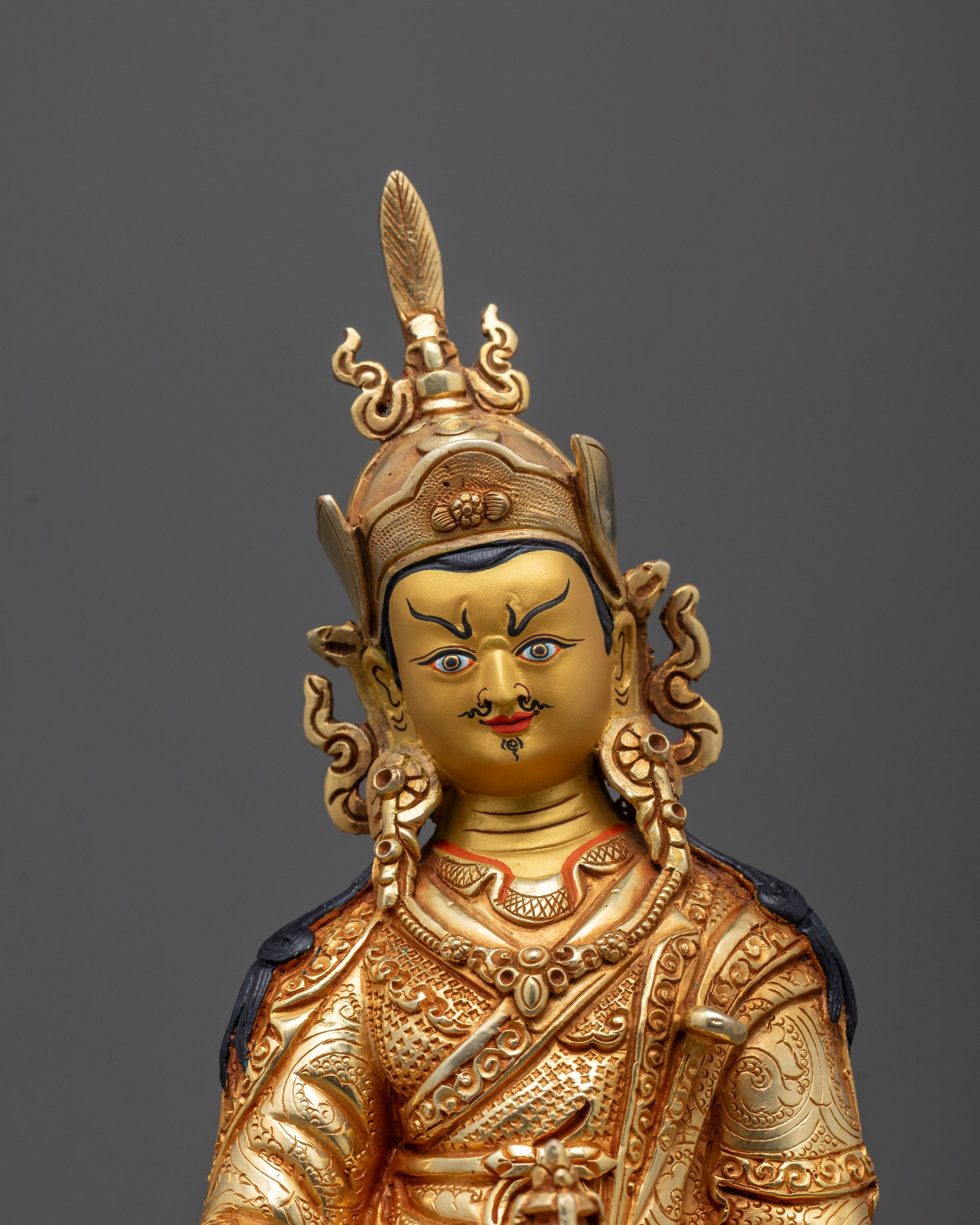 Close-up of Guru Rinpoche’s face with intricate crown and 24k fire gold gilding